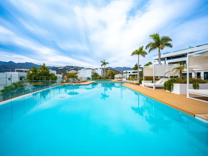 Penthouse Alma is a brand-new duplex home in a secure gated community in Marbella East. It has two ensuite bedrooms, a guest bathroom, and an open-plan living space that connects the kitchen, dining, and lounge areas. Floor-to-ceiling windows fill the hom