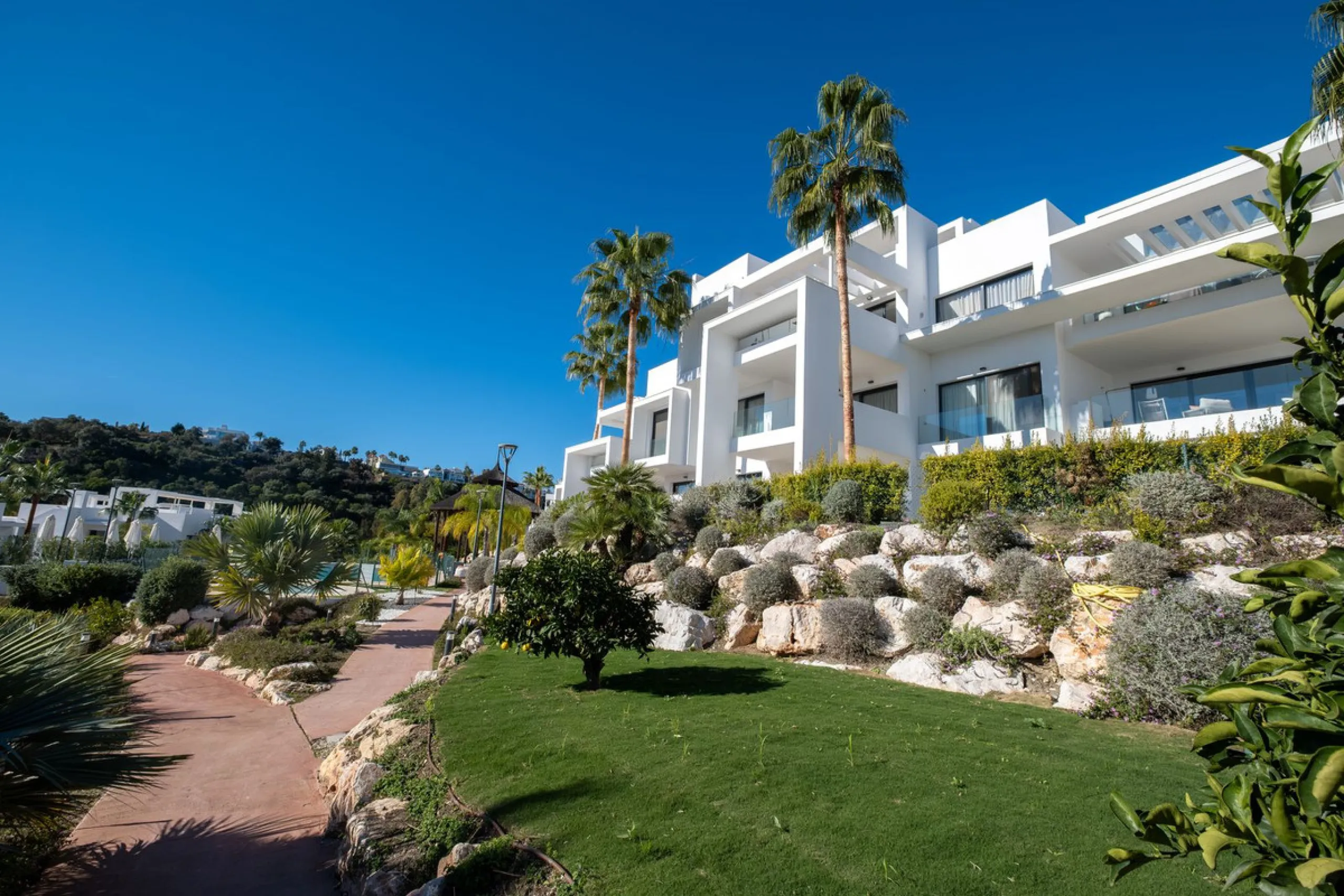 Discover the perfect blend of modern luxury and tranquility in this beautifully renovated 3-bedroom ground-floor apartment located in the prestigious Atalaya Hills. Offering breathtaking views over lush gardens, this stunning corner unit provides exceptio