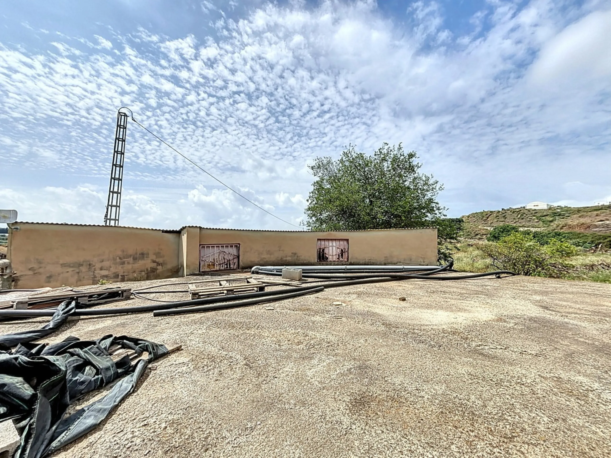 Nestled in the rolling hills of Valle Niza, this expansive agricultural estate of approximately 80,000 m2 offers a rare opportunity for farmers, investors, or visionaries seeking a versatile plot of land. The property features a large water reservoir with