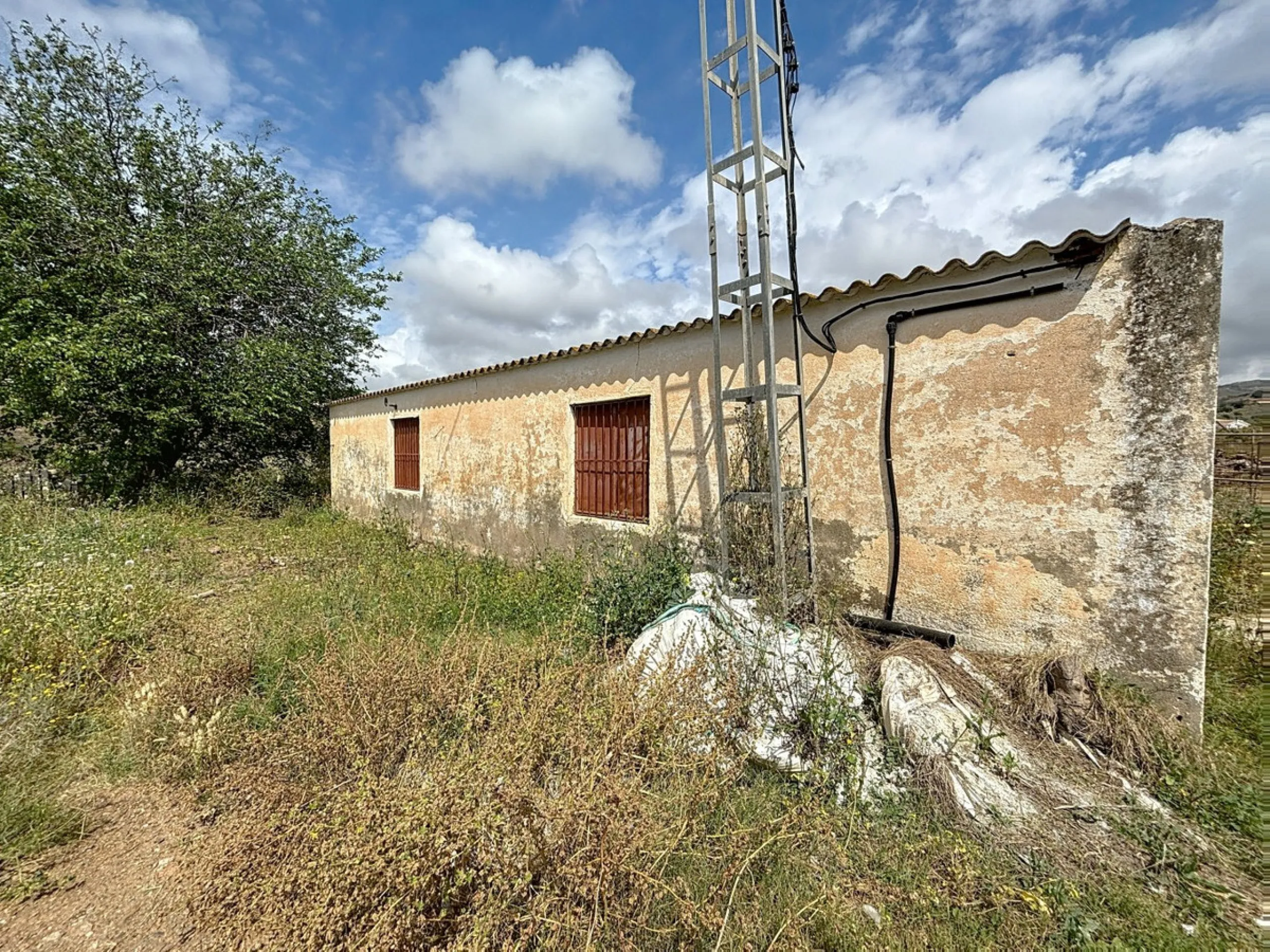 Nestled in the rolling hills of Valle Niza, this expansive agricultural estate of approximately 80,000 m2 offers a rare opportunity for farmers, investors, or visionaries seeking a versatile plot of land. The property features a large water reservoir with