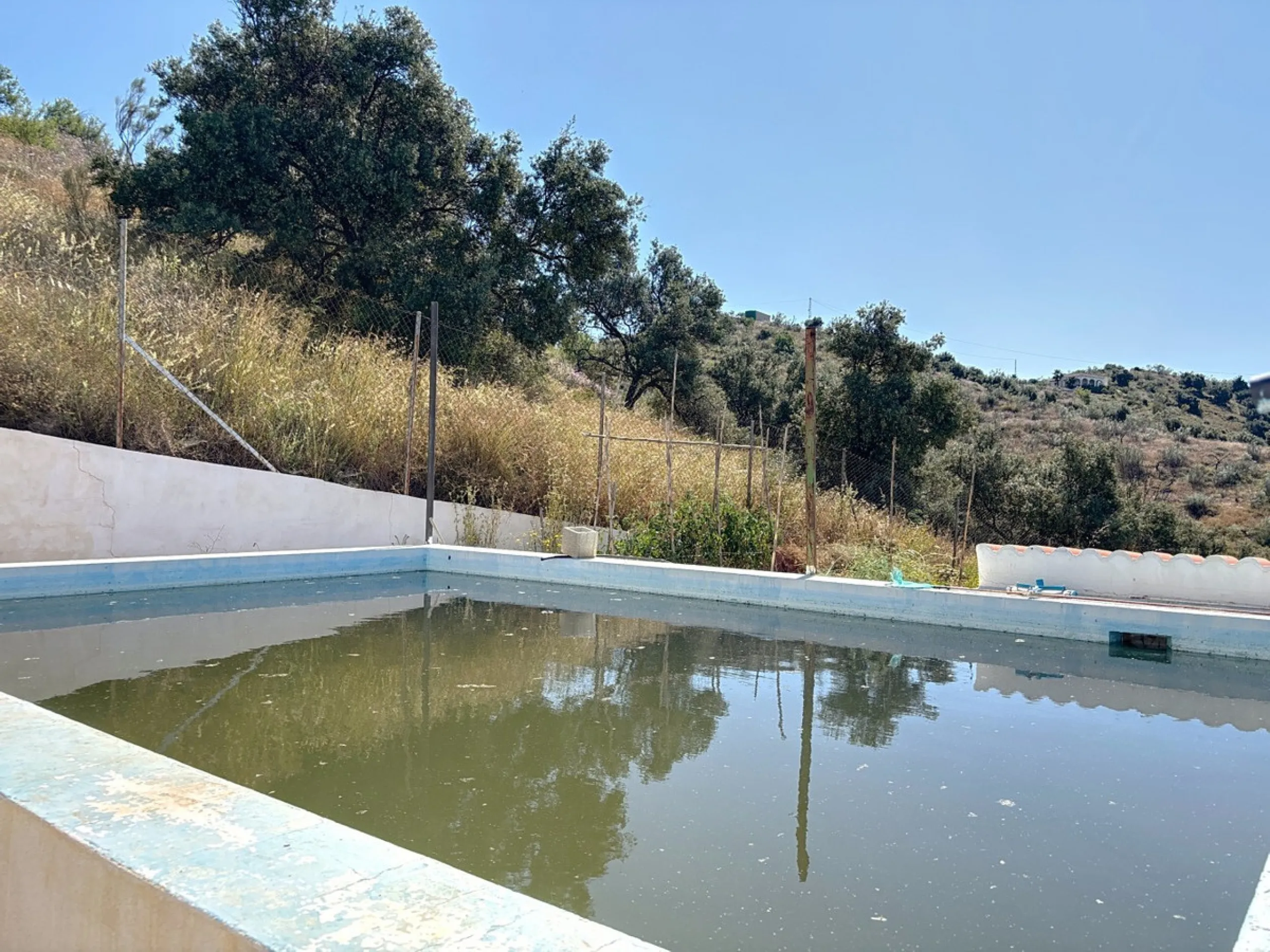 Nestled in the peaceful hills of Almayate Alto, this charming finca offers a rare opportunity to enjoy country living with breathtaking sea views. The property features a cozy 80m2 house with three bedrooms and one bathroom, ideal for those seeking a tran