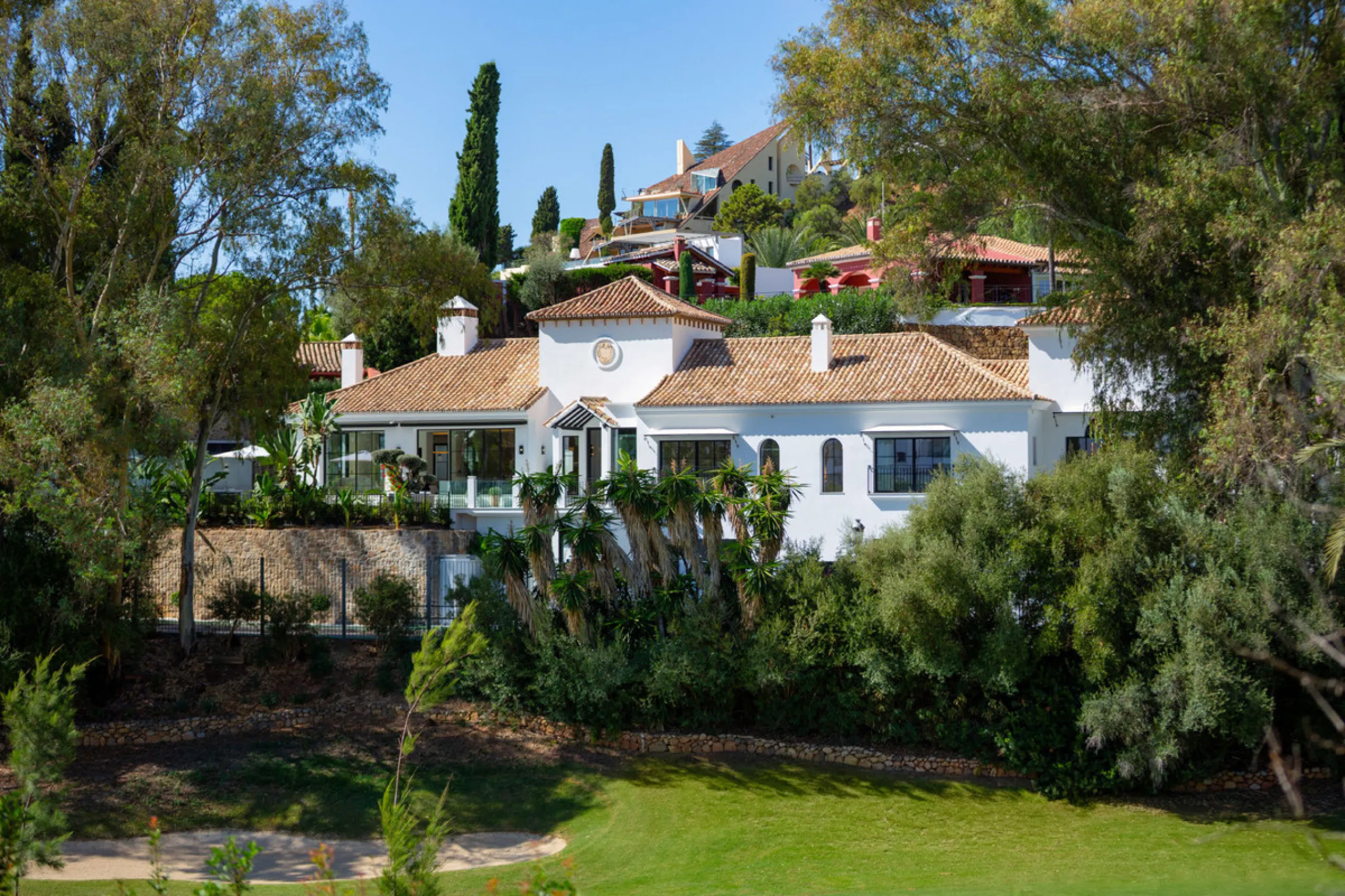 Exceptional villa for sale in the prestigious gated community of El Herrojo Alto, one of La Quinta's most sought-after residential areas. Positioned on an elevated frontline golf plot, this landmark property harmoniously blends timeless Andalusian archite