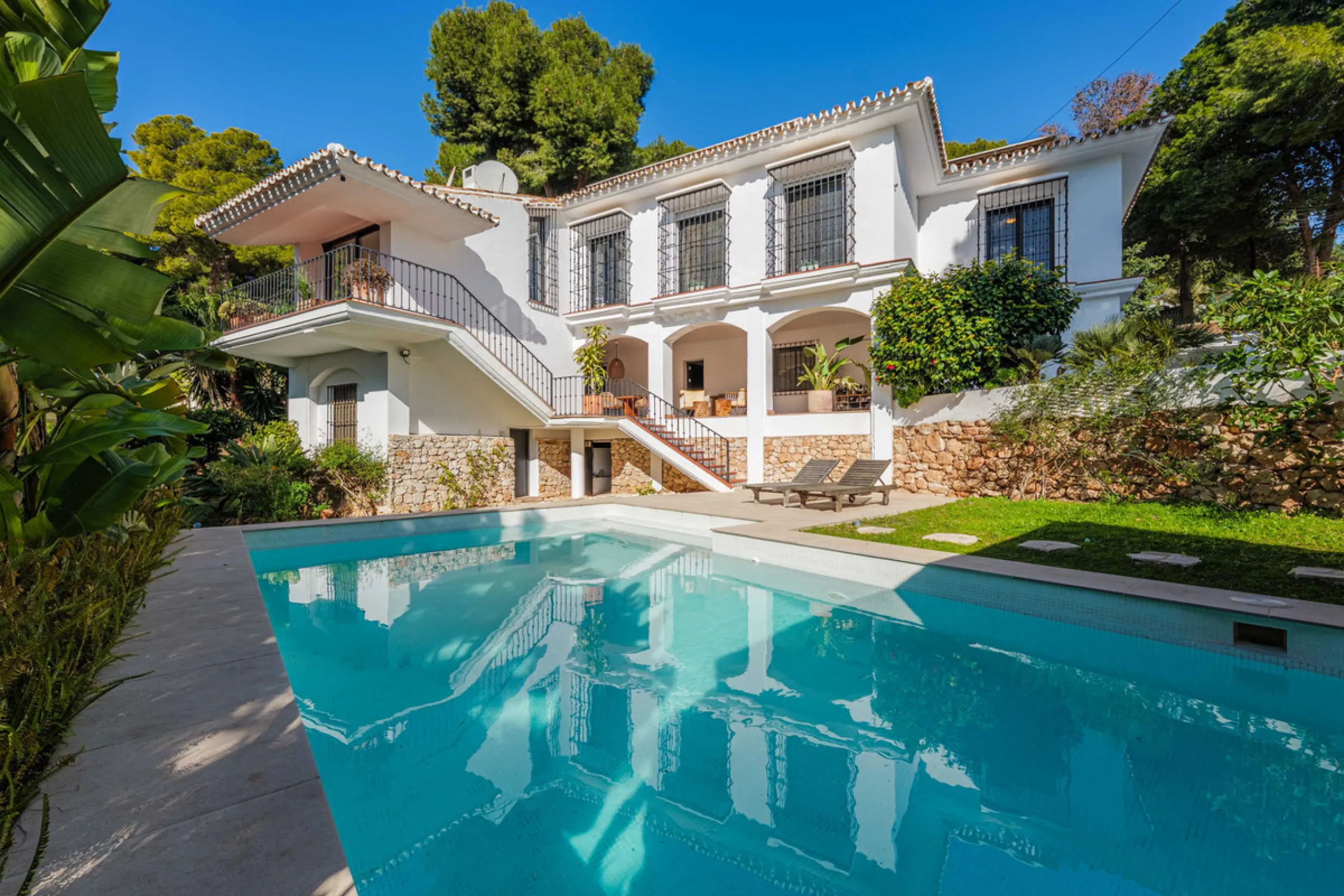Exclusive Mediterranean-style house in Pinares de San Antón, set on a spacious 1,184 m² plot. Its architecture combines the purity of a white façade with natural stone details and a terracotta-tiled roof, creating a harmonious and timeless ensemble. The p