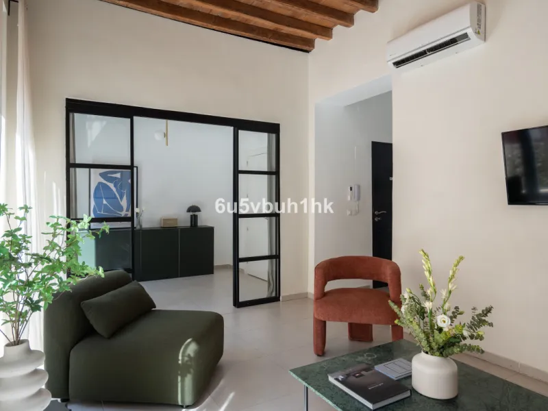 Imagine living in Málaga's historic center, on a wide and quiet street just a stone's throw from Calle Carretería. This apartment has something rare—a feeling of space, privacy, and uplifting light that fills every room. Step out onto any of the three sun