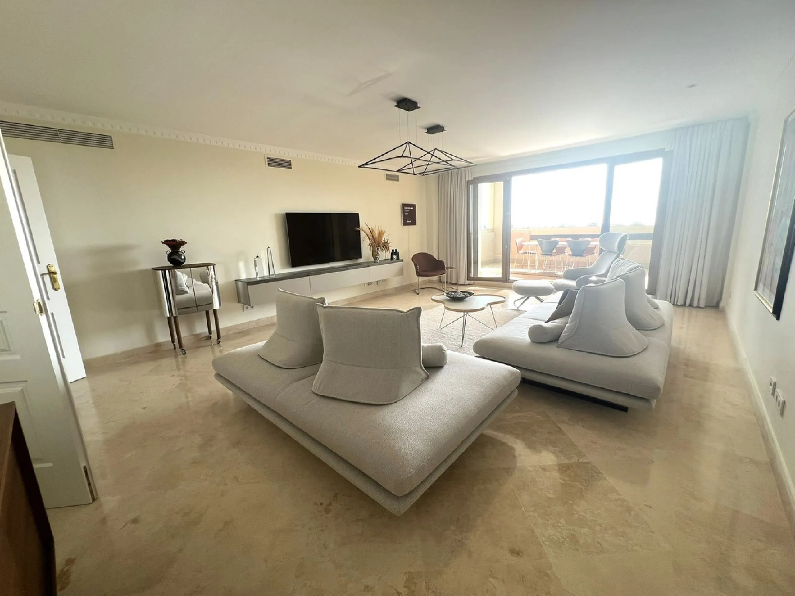 Discover this exceptional first-floor corner apartment, where modern comfort meets breathtaking scenery. Boasting two expansive, glassed in terraces, the residence offers panoramic views that stretch from the sparkling Mediterranean Sea to the majestic su