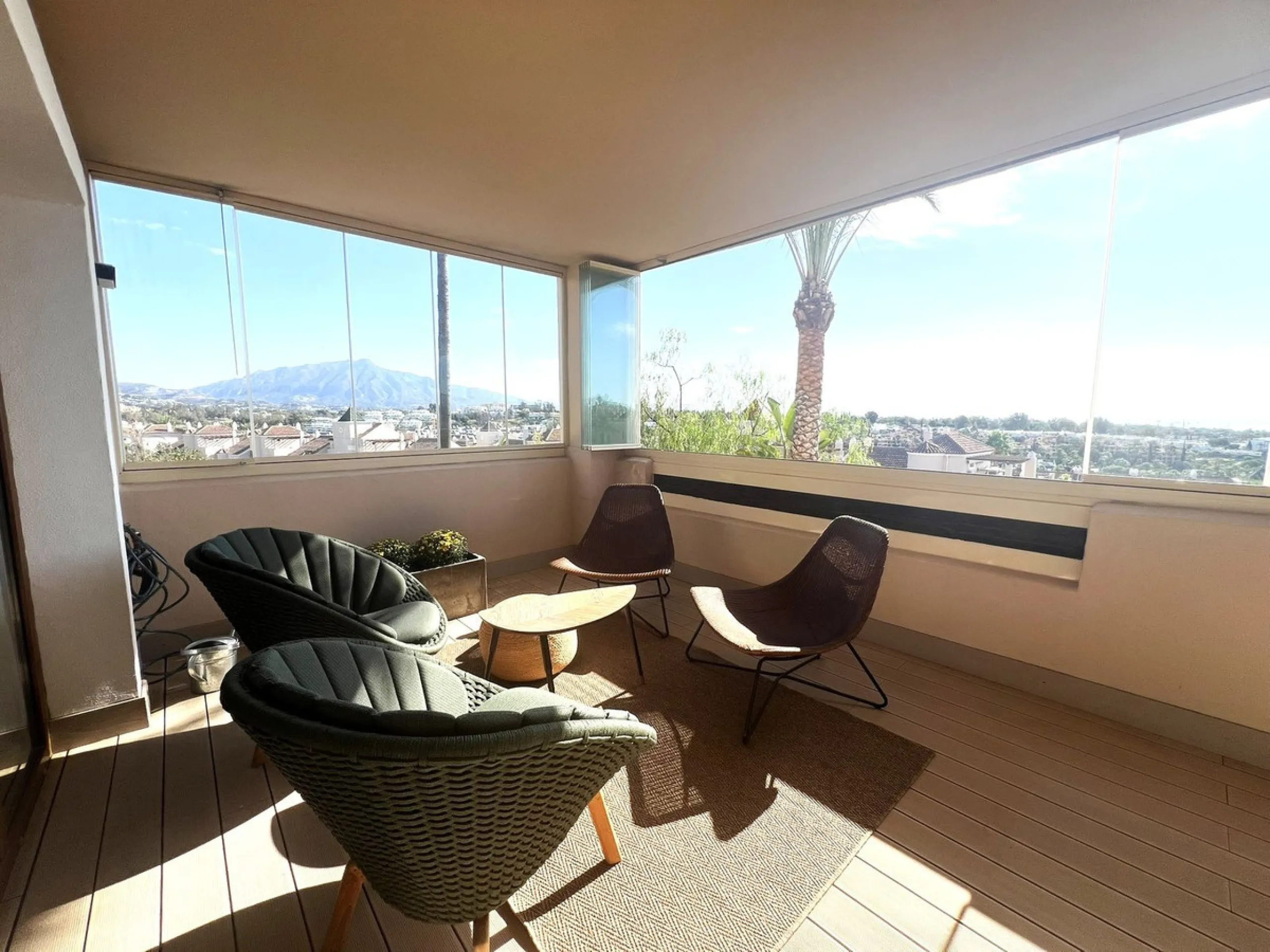Discover this exceptional first-floor corner apartment, where modern comfort meets breathtaking scenery. Boasting two expansive, glassed in terraces, the residence offers panoramic views that stretch from the sparkling Mediterranean Sea to the majestic su