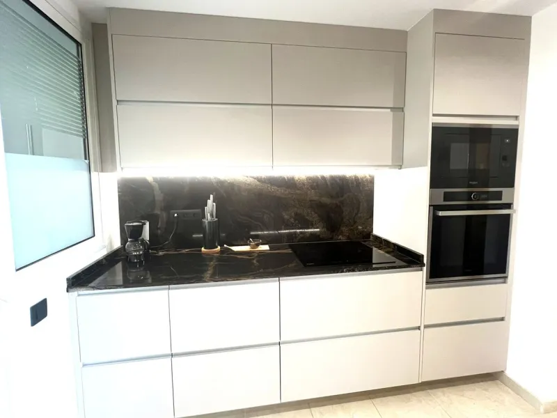 Discover this exceptional first-floor corner apartment, where modern comfort meets breathtaking scenery. Boasting two expansive, glassed in terraces, the residence offers panoramic views that stretch from the sparkling Mediterranean Sea to the majestic su