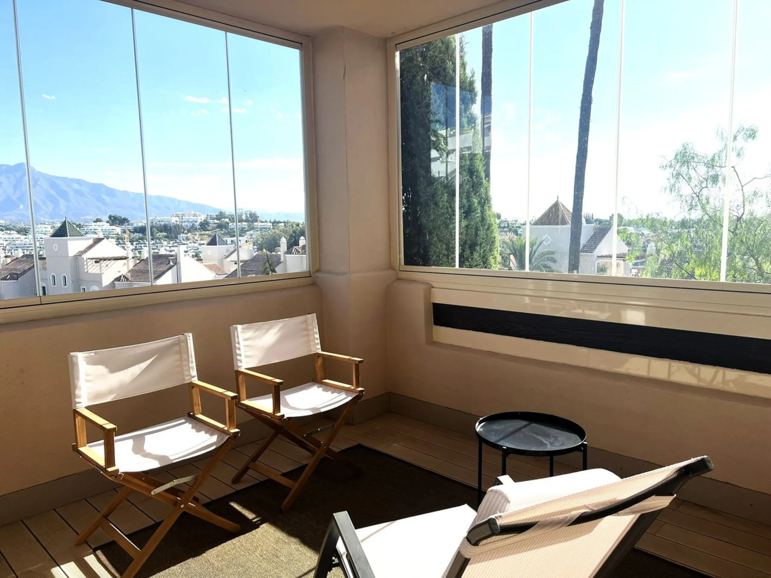 Discover this exceptional first-floor corner apartment, where modern comfort meets breathtaking scenery. Boasting two expansive, glassed in terraces, the residence offers panoramic views that stretch from the sparkling Mediterranean Sea to the majestic su