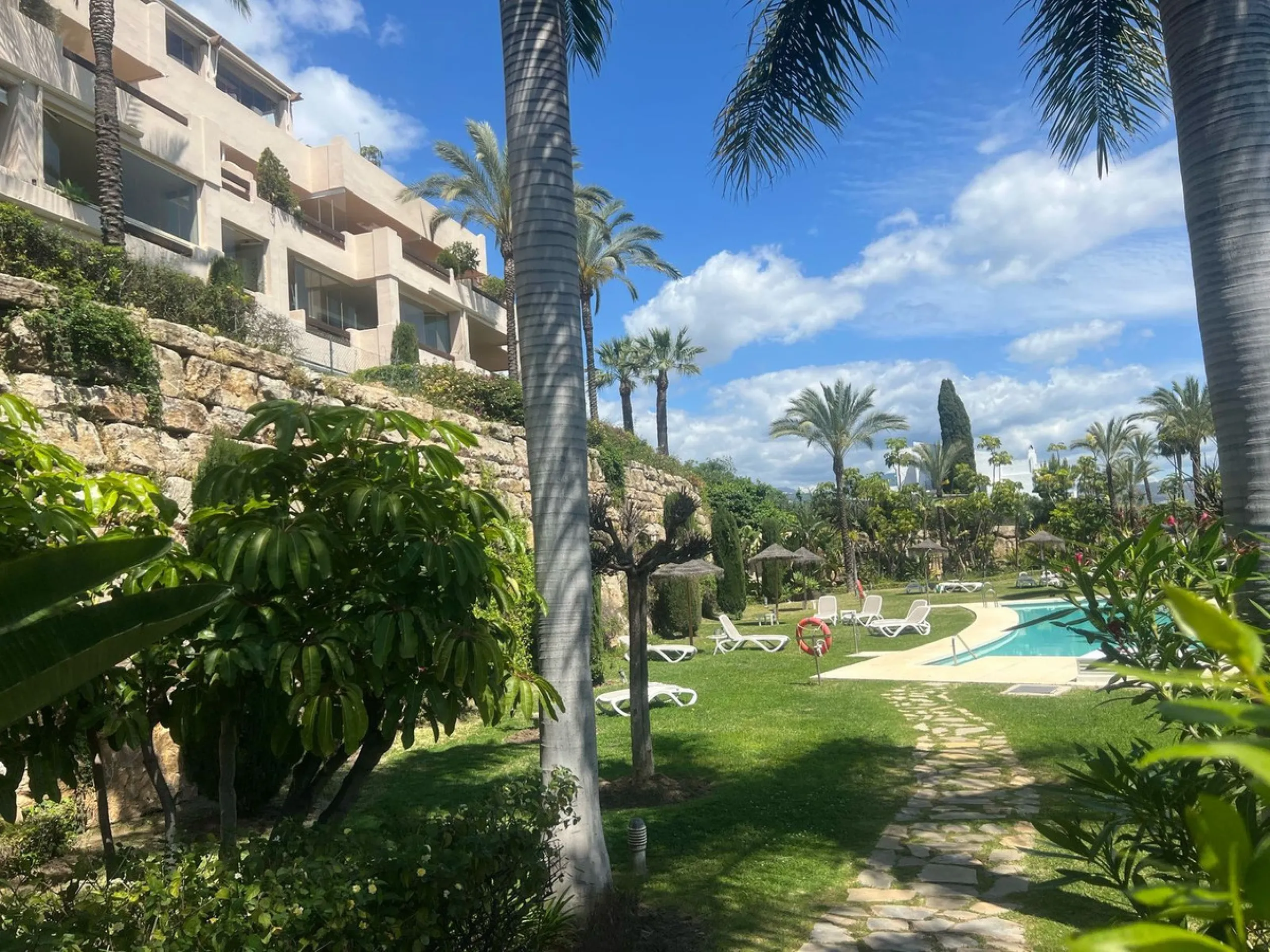 Discover this exceptional first-floor corner apartment, where modern comfort meets breathtaking scenery. Boasting two expansive, glassed in terraces, the residence offers panoramic views that stretch from the sparkling Mediterranean Sea to the majestic su