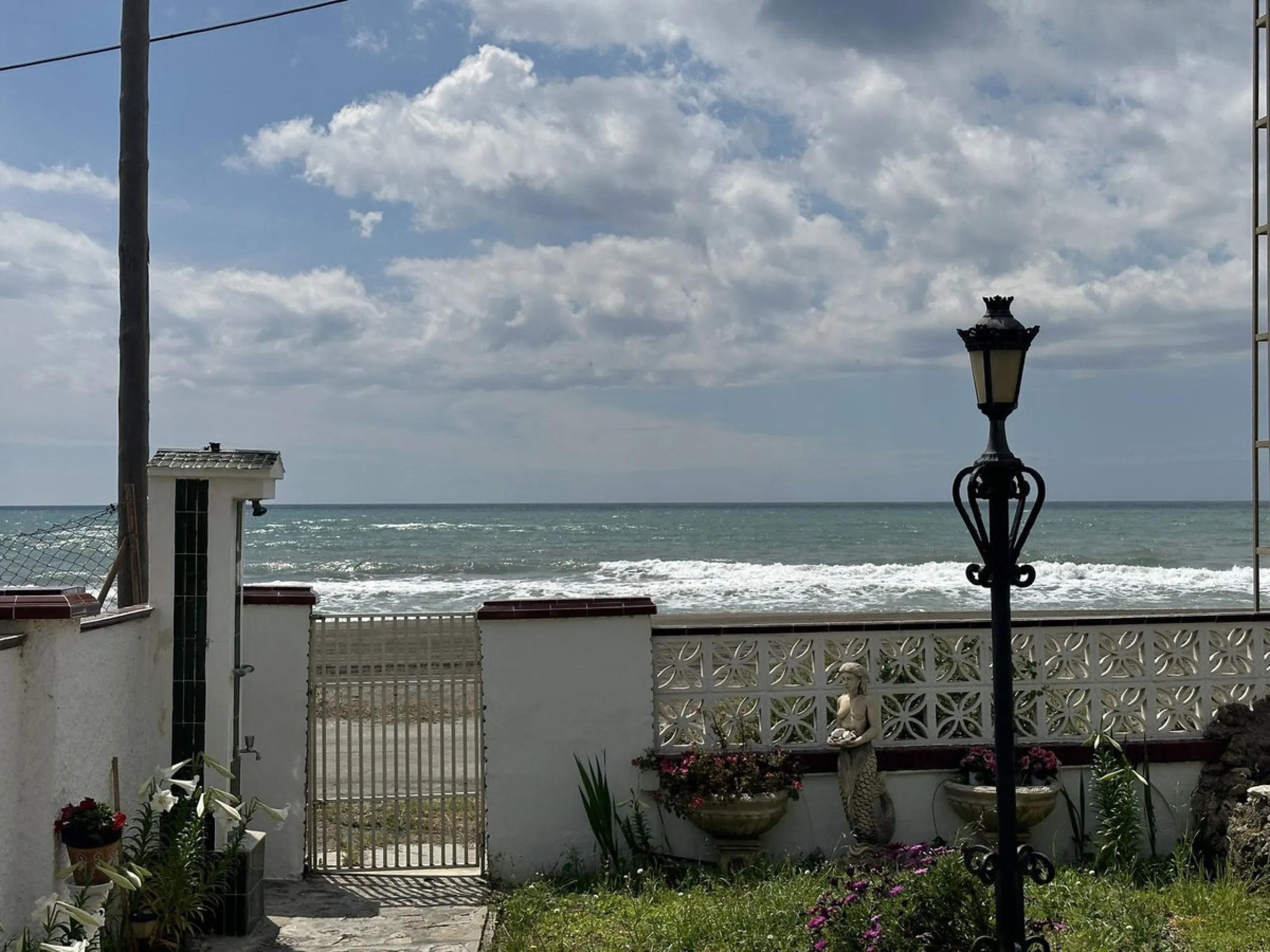 Beachfront! Semi-detached house in need of renovation with direct access to the beach, a beautiful front garden with the possibility of creating a pool, and a cozy patio at the rear. It is distributed over two floors: a living-dining room, a bathroom, and