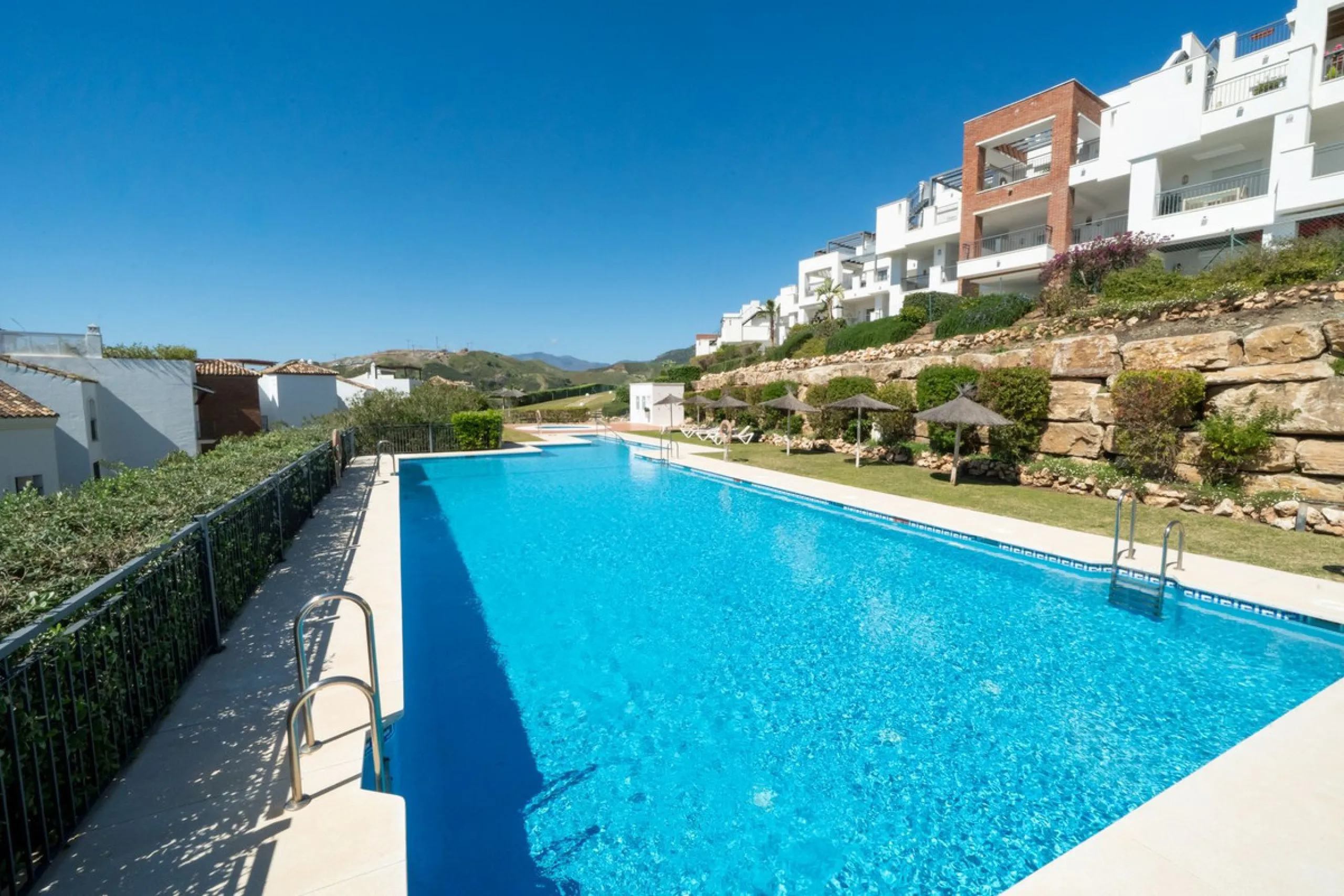Modern 2-bedroom, 2-bathroom apartment in the sought-after urbanisation Los Robles de Los Arqueros. Enjoy a spacious west-facing terrace with afternoon sun and stunning views over El Higueral golf course. The property comes with a private underground park