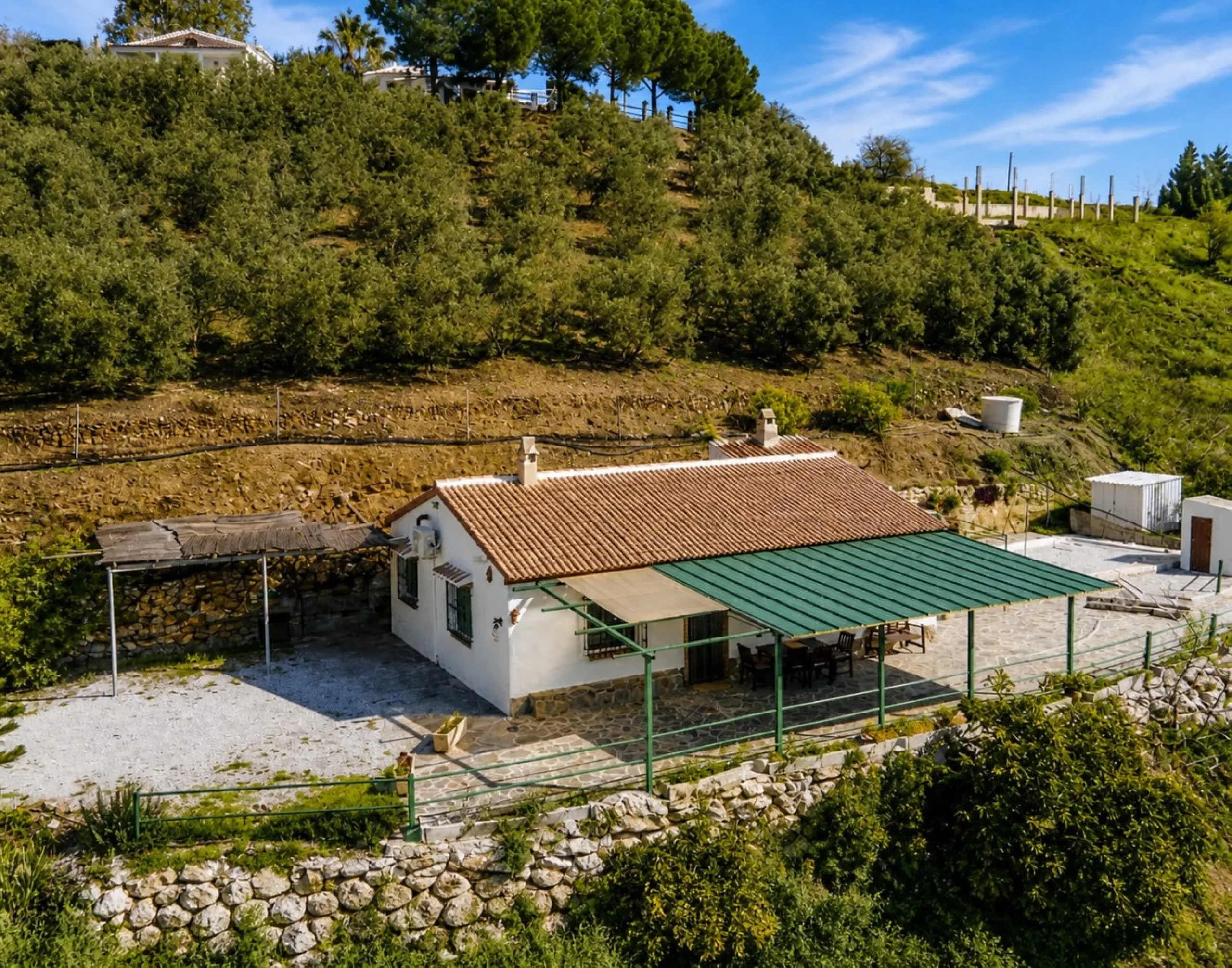 Nestled in the gentle hills below Cómpeta, with sweeping views of the surrounding mountains, this charming country house in traditional Andalusian style offers a peaceful retreat for nature lovers and those seeking tranquility. The single-storey house fea
