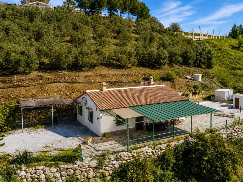 Nestled in the gentle hills below Cómpeta, with sweeping views of the surrounding mountains, this charming country house in traditional Andalusian style offers a peaceful retreat for nature lovers and those seeking tranquility. The single-storey house fea