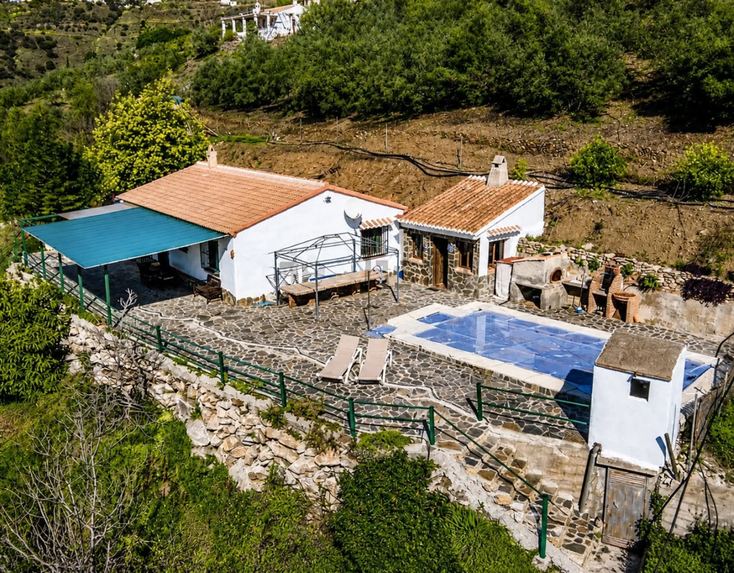Nestled in the gentle hills below Cómpeta, with sweeping views of the surrounding mountains, this charming country house in traditional Andalusian style offers a peaceful retreat for nature lovers and those seeking tranquility. The single-storey house fea