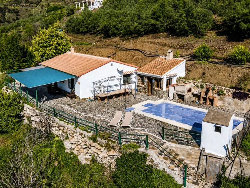 Nestled in the gentle hills below Cómpeta, with sweeping views of the surrounding mountains, this charming country house in traditional Andalusian style offers a peaceful retreat for nature lovers and those seeking tranquility. The single-storey house fea