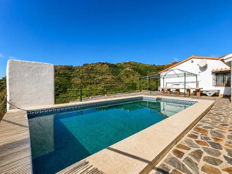 Nestled in the gentle hills below Cómpeta, with sweeping views of the surrounding mountains, this charming country house in traditional Andalusian style offers a peaceful retreat for nature lovers and those seeking tranquility. The single-storey house fea