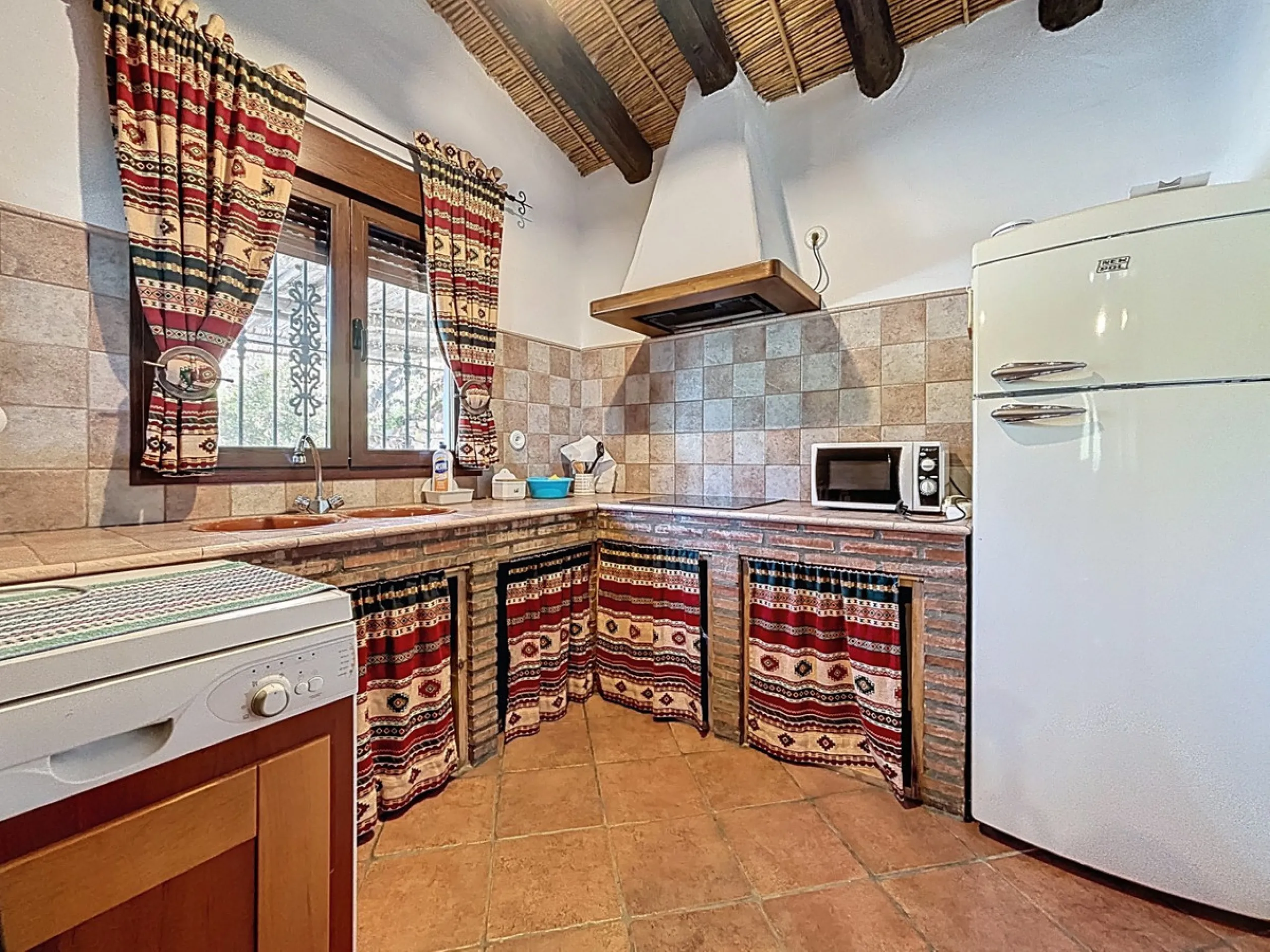 Nestled in the gentle hills below Cómpeta, with sweeping views of the surrounding mountains, this charming country house in traditional Andalusian style offers a peaceful retreat for nature lovers and those seeking tranquility. The single-storey house fea