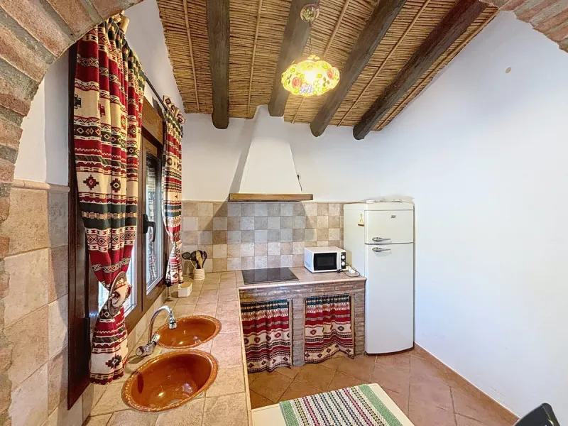 Nestled in the gentle hills below Cómpeta, with sweeping views of the surrounding mountains, this charming country house in traditional Andalusian style offers a peaceful retreat for nature lovers and those seeking tranquility. The single-storey house fea