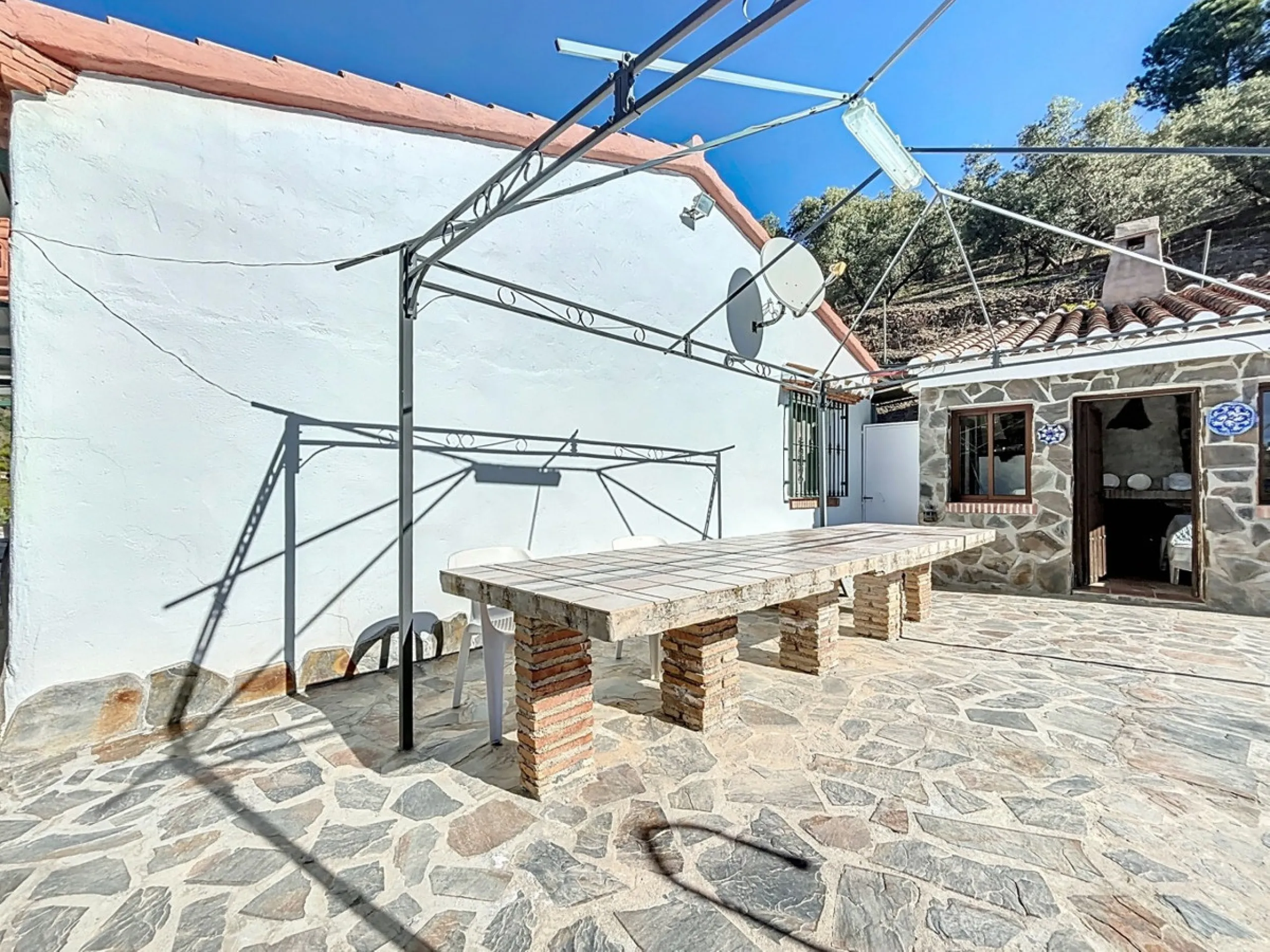 Nestled in the gentle hills below Cómpeta, with sweeping views of the surrounding mountains, this charming country house in traditional Andalusian style offers a peaceful retreat for nature lovers and those seeking tranquility. The single-storey house fea