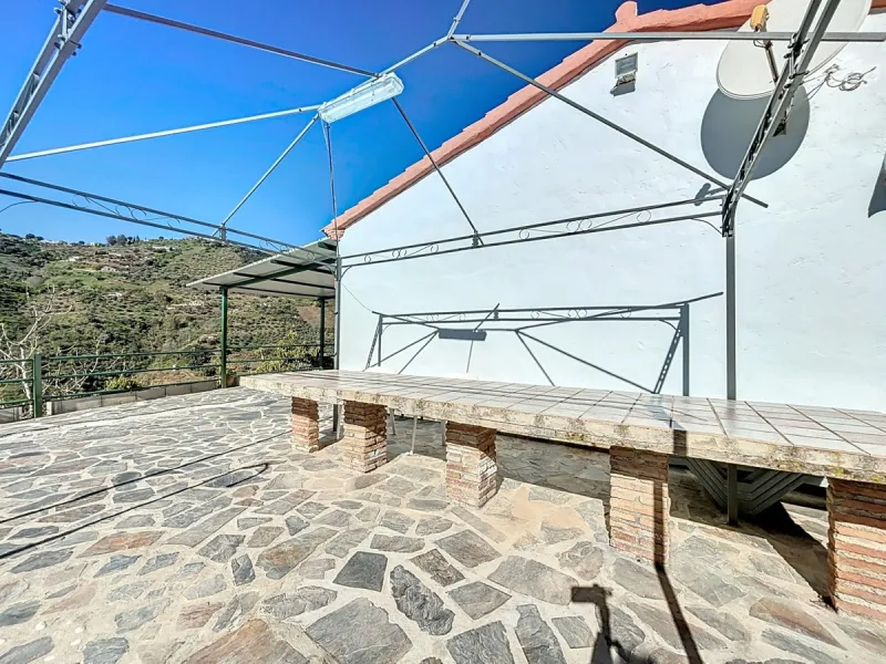Nestled in the gentle hills below Cómpeta, with sweeping views of the surrounding mountains, this charming country house in traditional Andalusian style offers a peaceful retreat for nature lovers and those seeking tranquility. The single-storey house fea