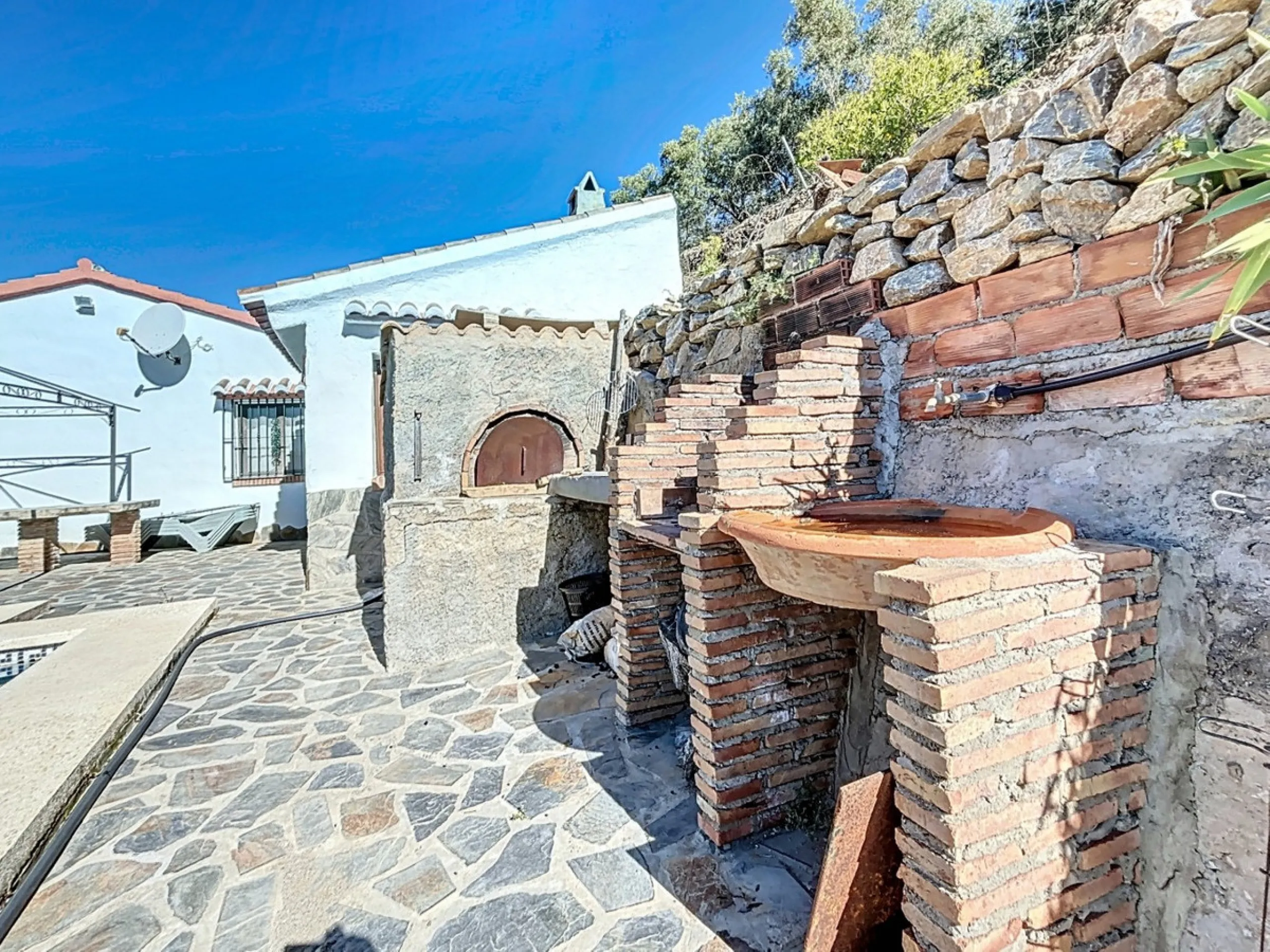 Nestled in the gentle hills below Cómpeta, with sweeping views of the surrounding mountains, this charming country house in traditional Andalusian style offers a peaceful retreat for nature lovers and those seeking tranquility. The single-storey house fea