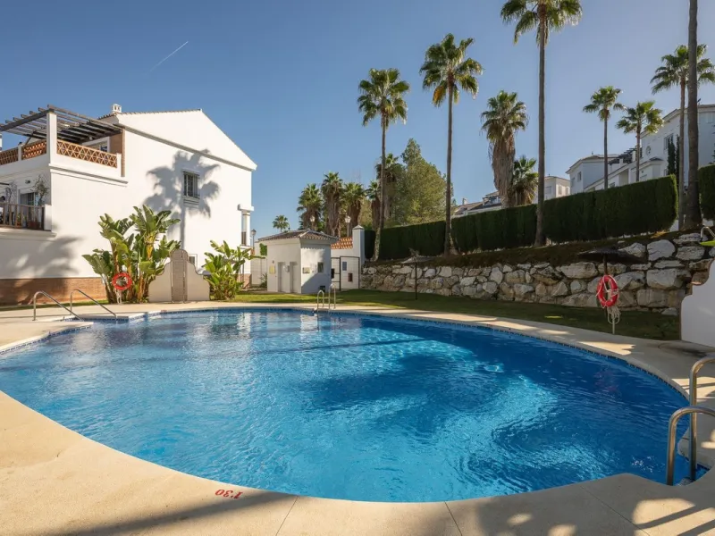 Townhouse for sale in Lauro Golf one of the most prestigious golf courses in Malaga. The property is distributed over three floors. On the ground floor there is a fully equipped kitchen, a toilet, a large living room with a fireplace that leads to a priva