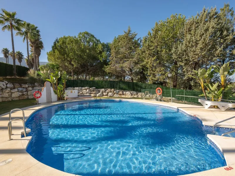 Townhouse for sale in Lauro Golf one of the most prestigious golf courses in Malaga. The property is distributed over three floors. On the ground floor there is a fully equipped kitchen, a toilet, a large living room with a fireplace that leads to a priva