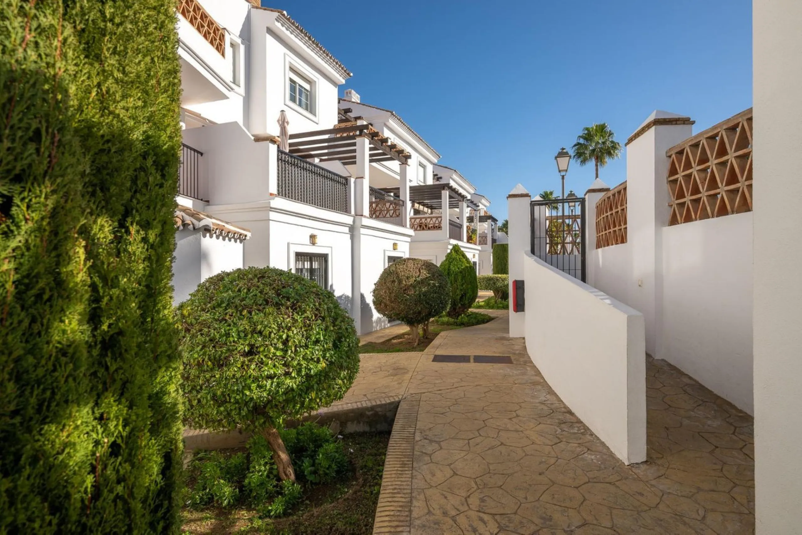 Townhouse for sale in Lauro Golf one of the most prestigious golf courses in Malaga. The property is distributed over three floors. On the ground floor there is a fully equipped kitchen, a toilet, a large living room with a fireplace that leads to a priva