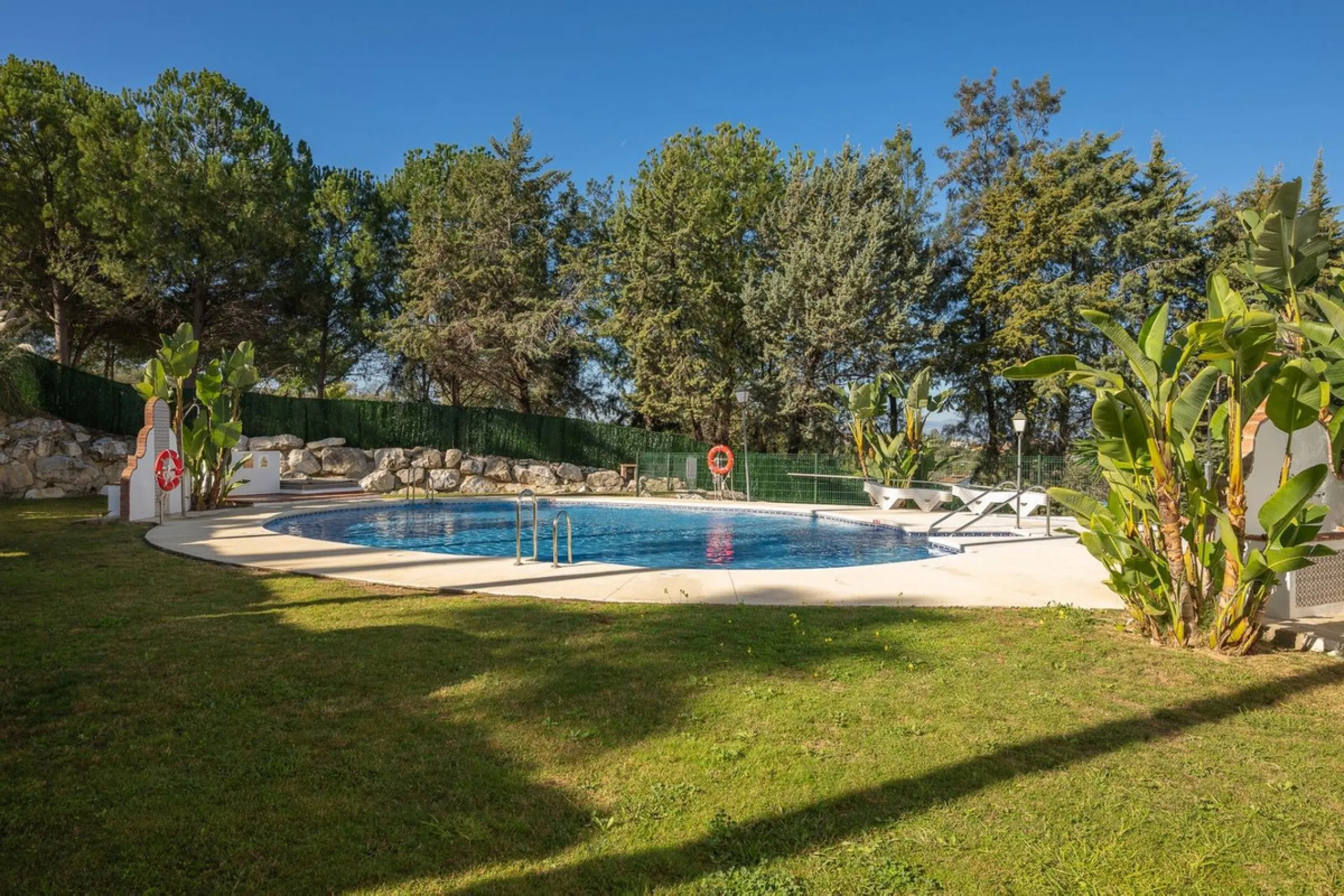 Townhouse for sale in Lauro Golf one of the most prestigious golf courses in Malaga. The property is distributed over three floors. On the ground floor there is a fully equipped kitchen, a toilet, a large living room with a fireplace that leads to a priva