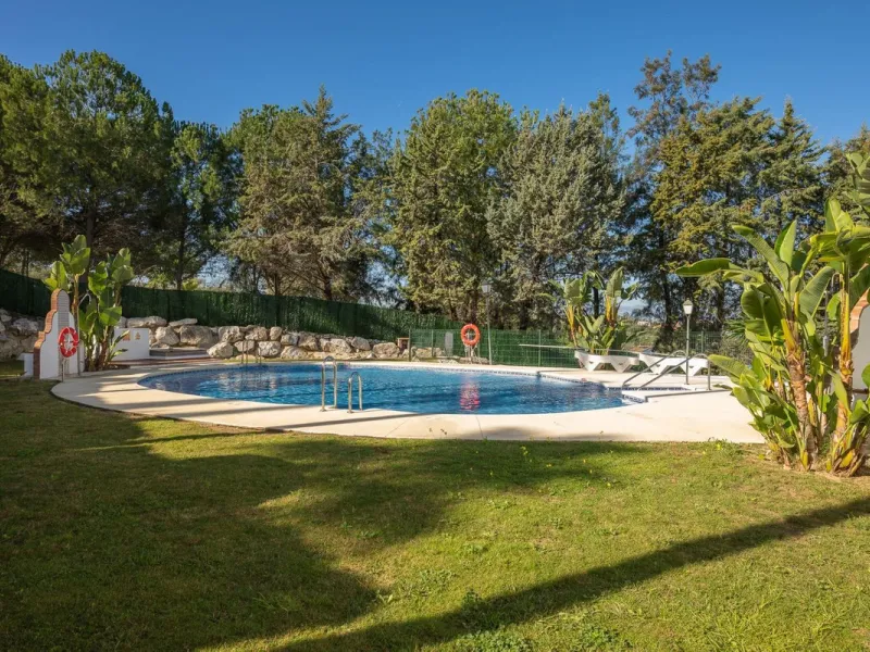 Townhouse for sale in Lauro Golf one of the most prestigious golf courses in Malaga. The property is distributed over three floors. On the ground floor there is a fully equipped kitchen, a toilet, a large living room with a fireplace that leads to a priva