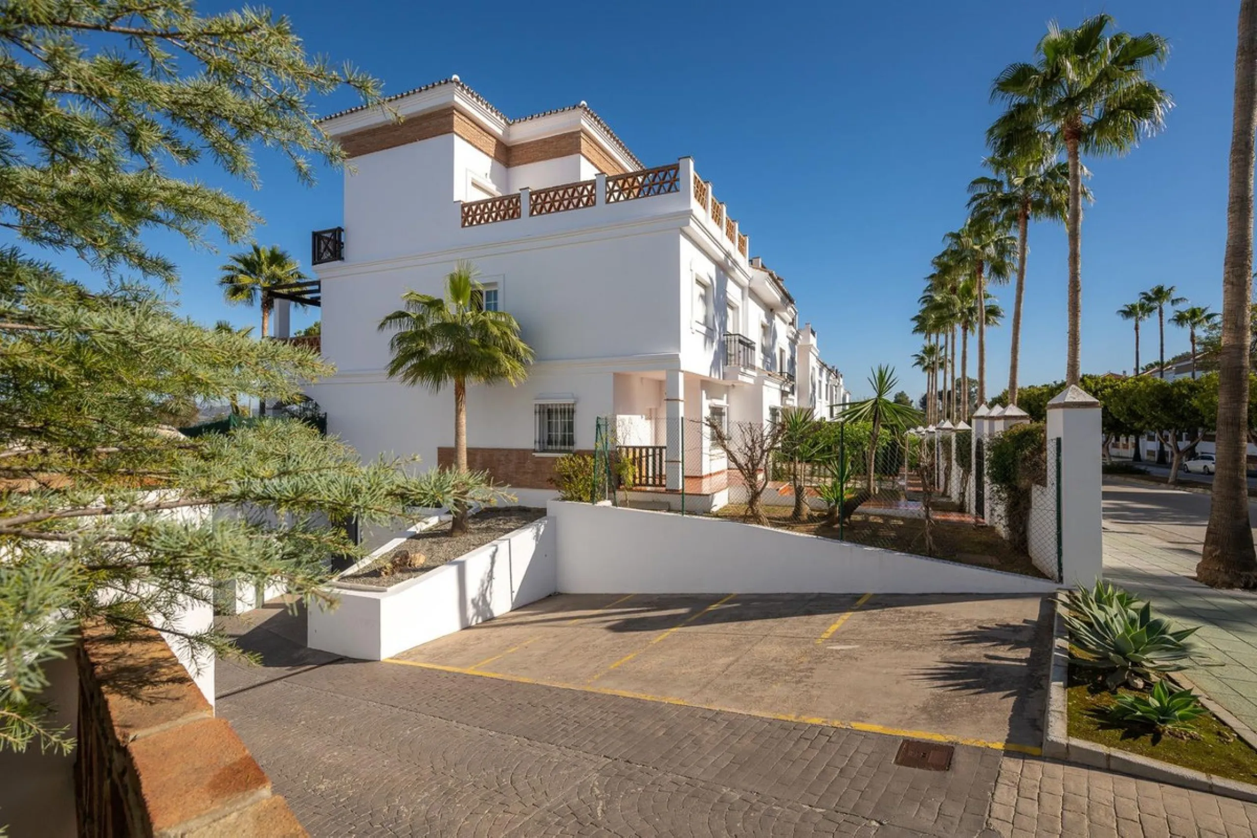 Townhouse for sale in Lauro Golf one of the most prestigious golf courses in Malaga. The property is distributed over three floors. On the ground floor there is a fully equipped kitchen, a toilet, a large living room with a fireplace that leads to a priva