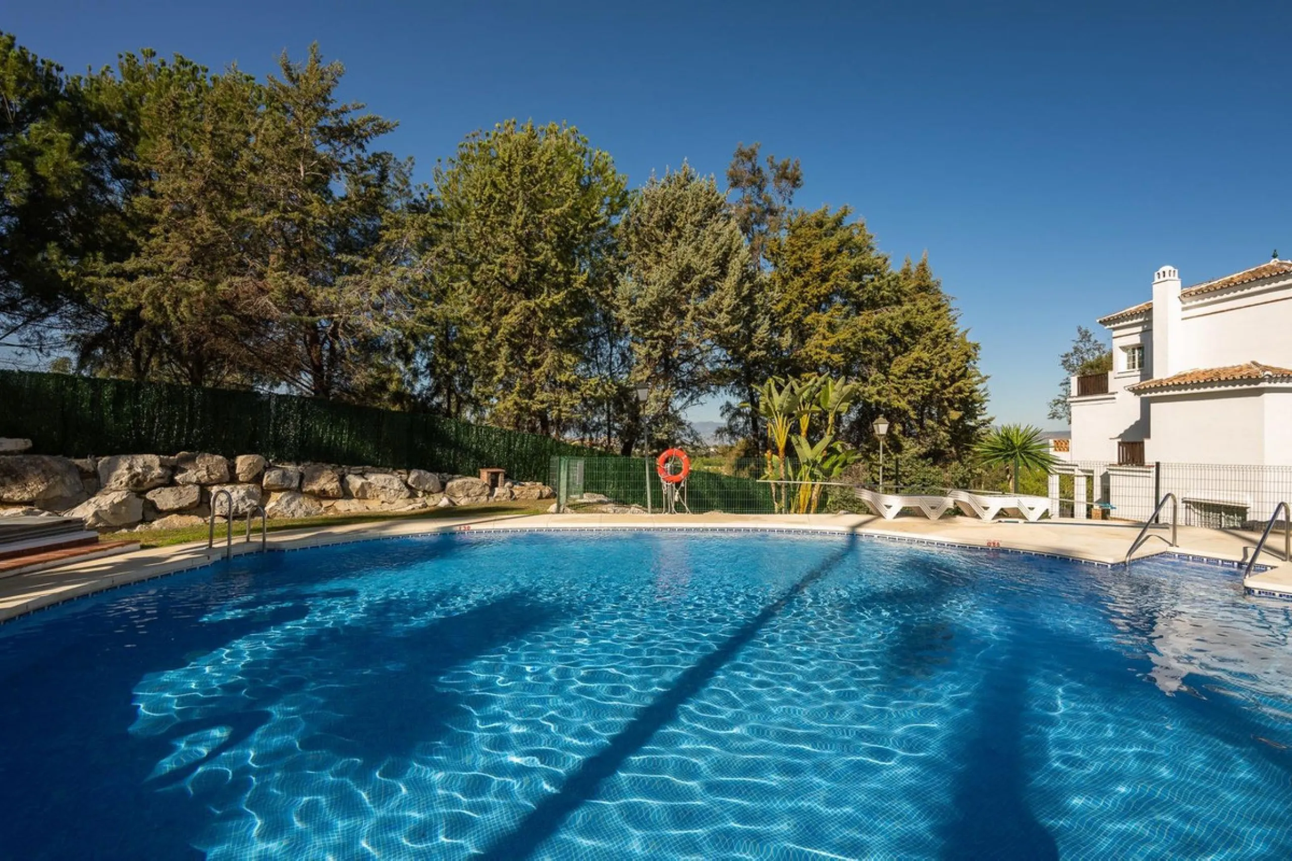 Townhouse for sale in Lauro Golf one of the most prestigious golf courses in Malaga. The property is distributed over three floors. On the ground floor there is a fully equipped kitchen, a toilet, a large living room with a fireplace that leads to a priva