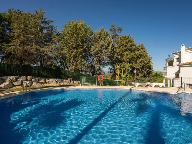 Townhouse for sale in Lauro Golf one of the most prestigious golf courses in Malaga. The property is distributed over three floors. On the ground floor there is a fully equipped kitchen, a toilet, a large living room with a fireplace that leads to a priva