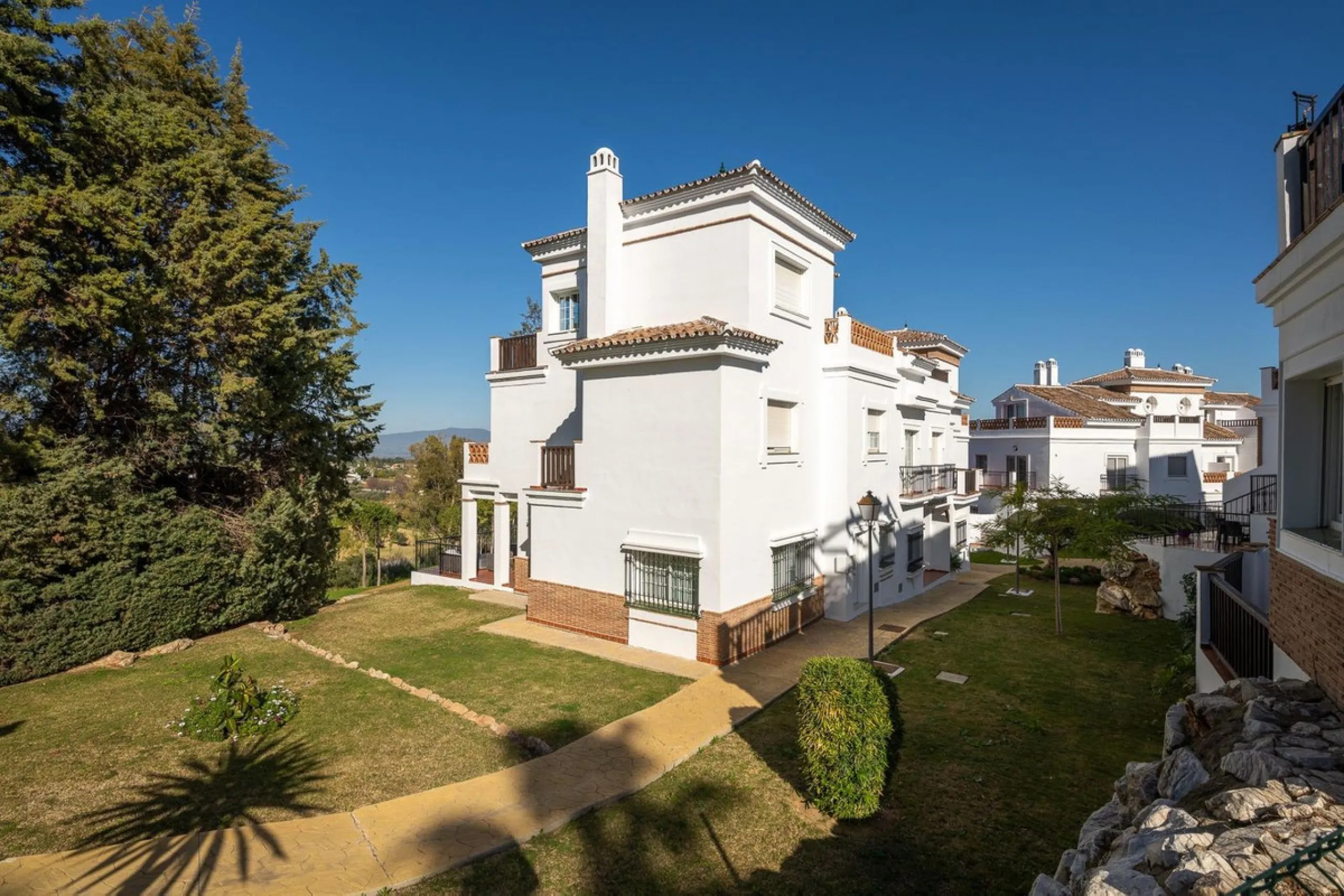 Townhouse for sale in Lauro Golf one of the most prestigious golf courses in Malaga. The property is distributed over three floors. On the ground floor there is a fully equipped kitchen, a toilet, a large living room with a fireplace that leads to a priva