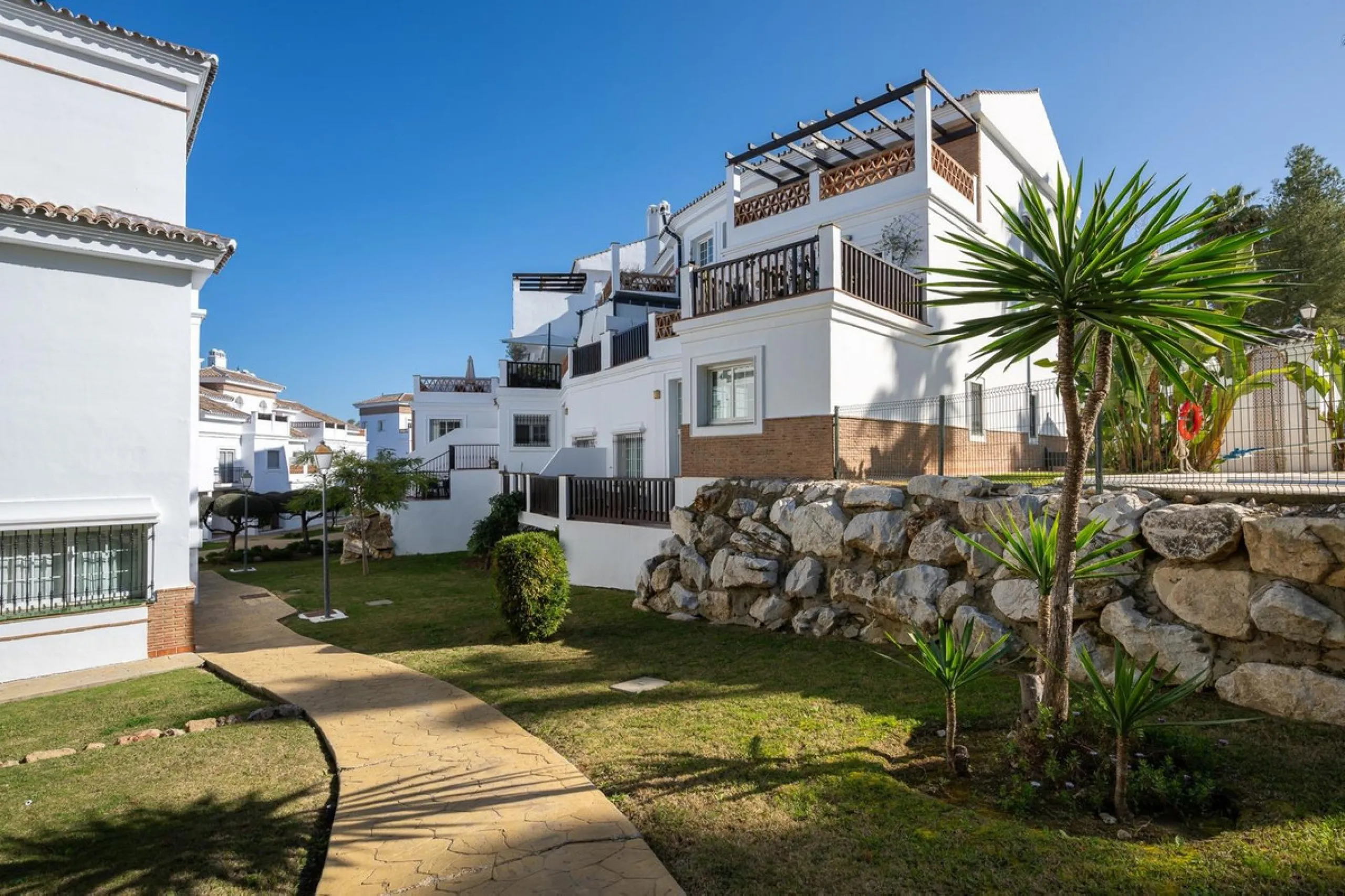 Townhouse for sale in Lauro Golf one of the most prestigious golf courses in Malaga. The property is distributed over three floors. On the ground floor there is a fully equipped kitchen, a toilet, a large living room with a fireplace that leads to a priva