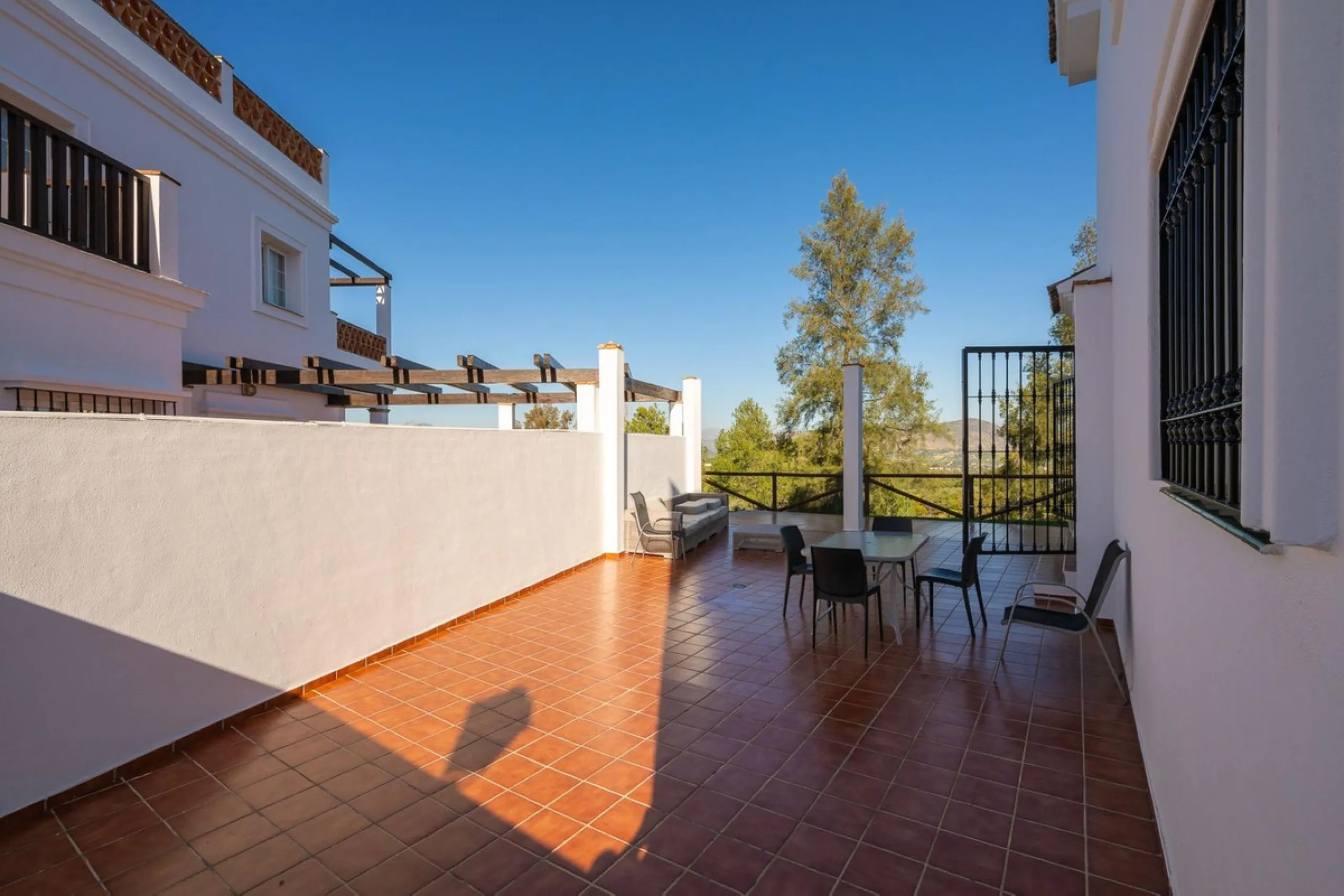 Townhouse for sale in Lauro Golf one of the most prestigious golf courses in Malaga. The property is distributed over three floors. On the ground floor there is a fully equipped kitchen, a toilet, a large living room with a fireplace that leads to a priva