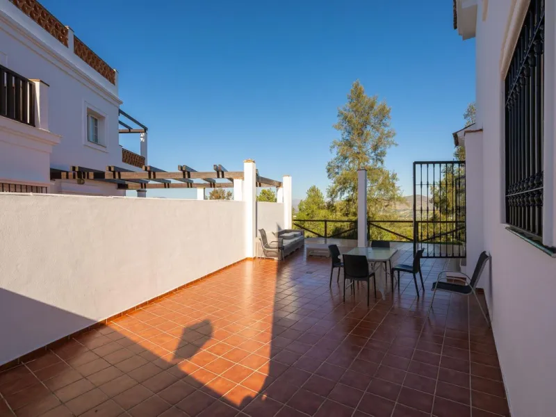 Townhouse for sale in Lauro Golf one of the most prestigious golf courses in Malaga. The property is distributed over three floors. On the ground floor there is a fully equipped kitchen, a toilet, a large living room with a fireplace that leads to a priva