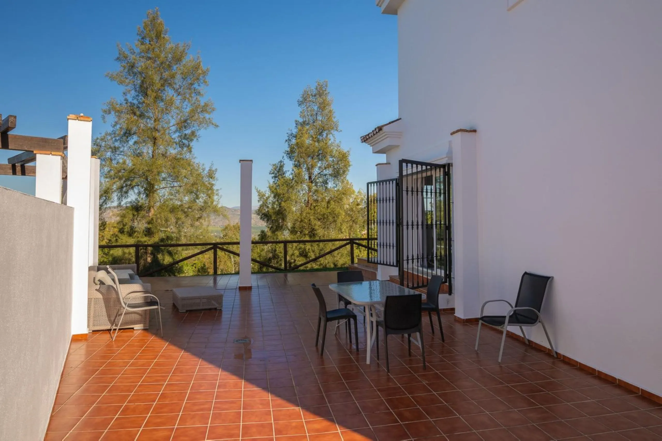 Townhouse for sale in Lauro Golf one of the most prestigious golf courses in Malaga. The property is distributed over three floors. On the ground floor there is a fully equipped kitchen, a toilet, a large living room with a fireplace that leads to a priva