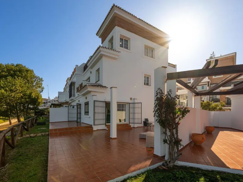 Townhouse for sale in Lauro Golf one of the most prestigious golf courses in Malaga. The property is distributed over three floors. On the ground floor there is a fully equipped kitchen, a toilet, a large living room with a fireplace that leads to a priva