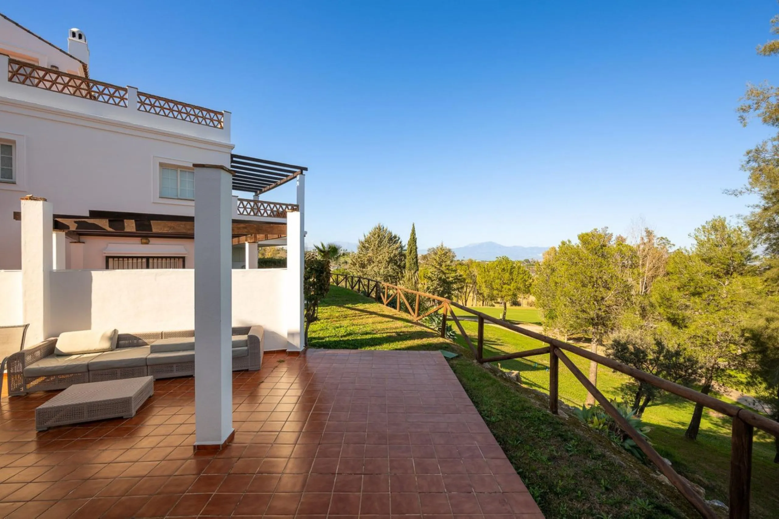 Townhouse for sale in Lauro Golf one of the most prestigious golf courses in Malaga. The property is distributed over three floors. On the ground floor there is a fully equipped kitchen, a toilet, a large living room with a fireplace that leads to a priva