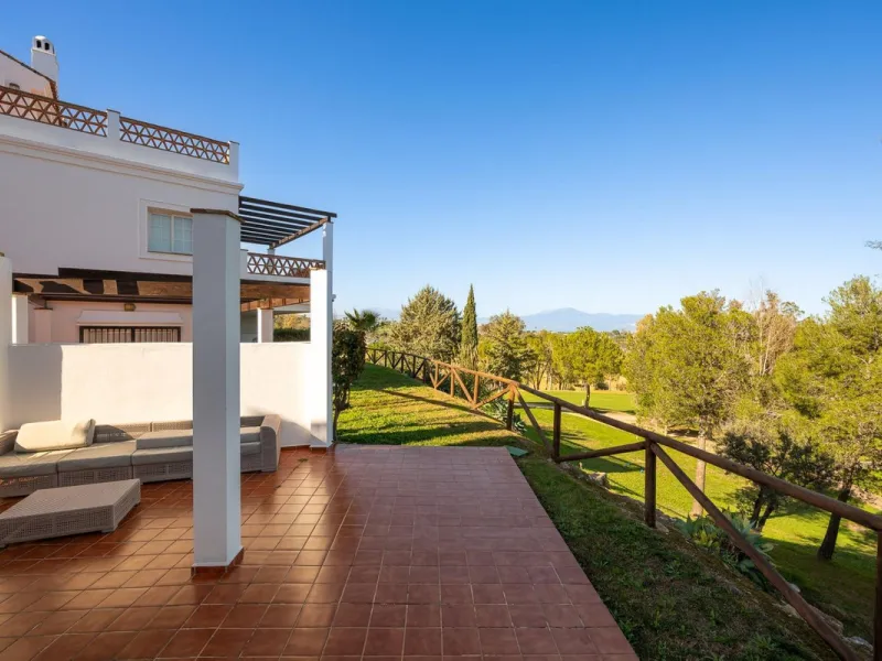 Townhouse for sale in Lauro Golf one of the most prestigious golf courses in Malaga. The property is distributed over three floors. On the ground floor there is a fully equipped kitchen, a toilet, a large living room with a fireplace that leads to a priva