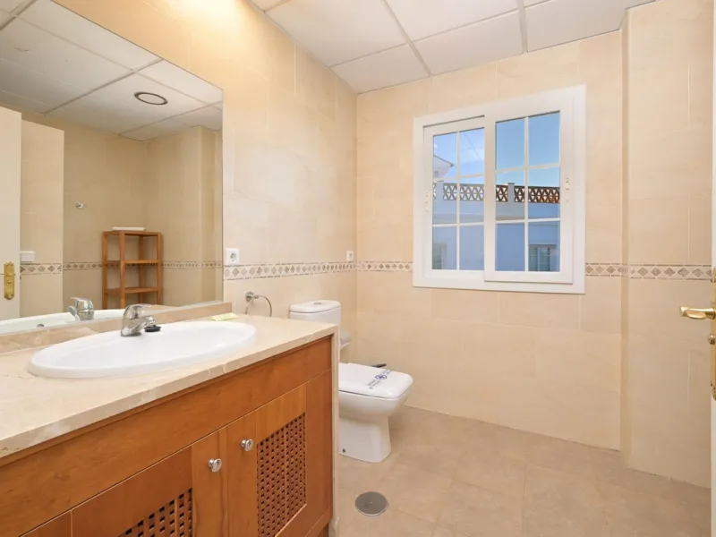 Townhouse for sale in Lauro Golf one of the most prestigious golf courses in Malaga. The property is distributed over three floors. On the ground floor there is a fully equipped kitchen, a toilet, a large living room with a fireplace that leads to a priva