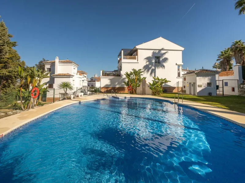Townhouse for sale in Lauro Golf one of the most prestigious golf courses in Malaga. The property is distributed over three floors. On the ground floor there is a fully equipped kitchen, a toilet, a large living room with a fireplace that leads to a priva