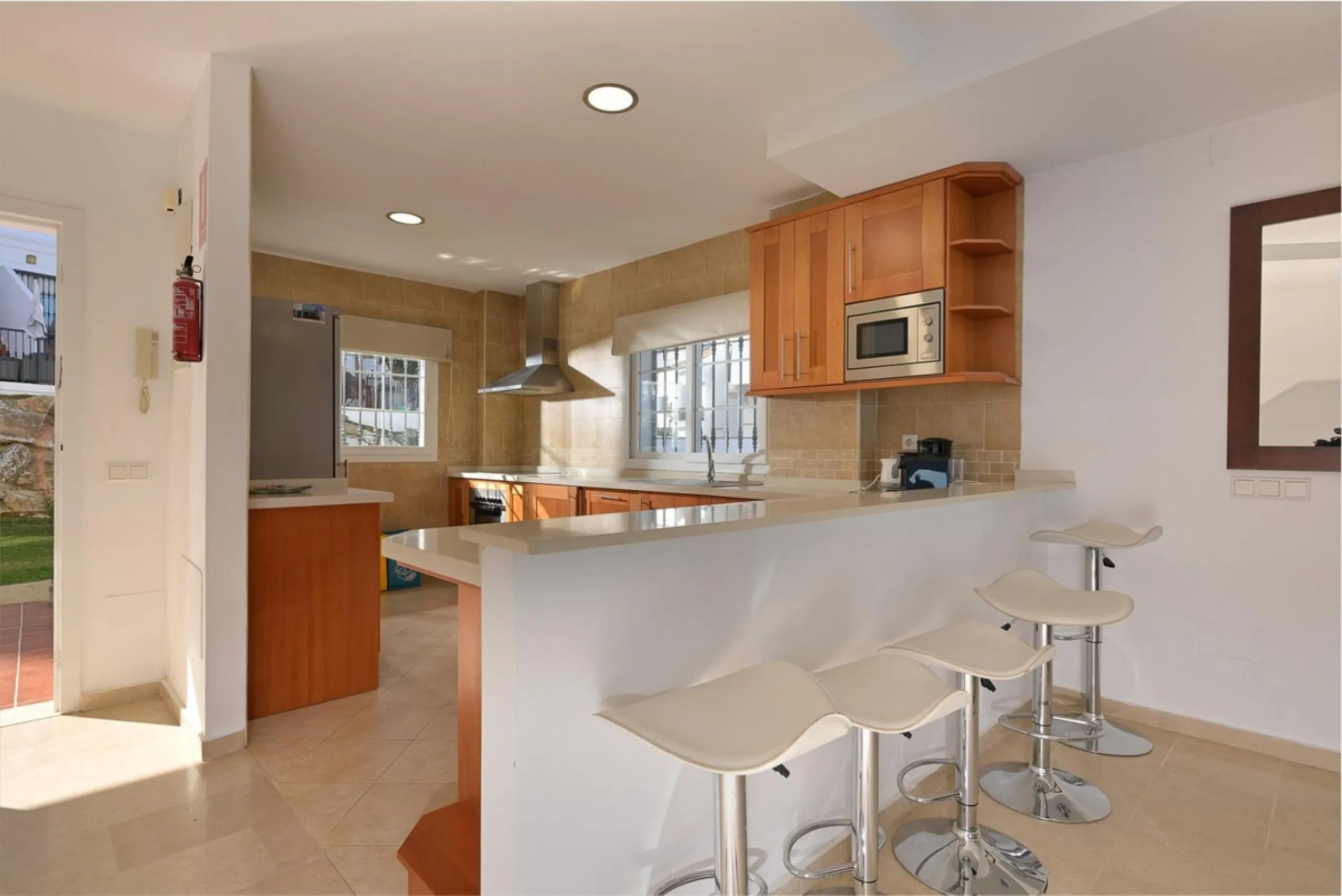 Townhouse for sale in Lauro Golf one of the most prestigious golf courses in Malaga. The property is distributed over three floors. On the ground floor there is a fully equipped kitchen, a toilet, a large living room with a fireplace that leads to a priva