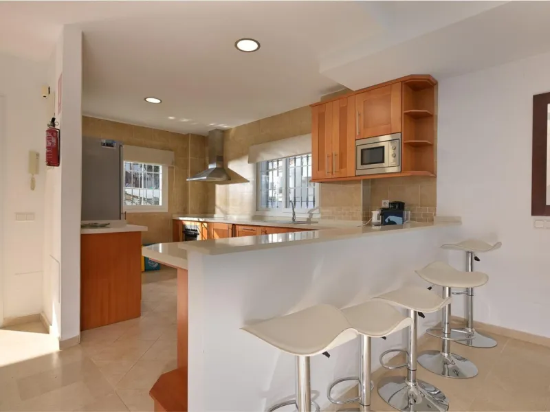 Townhouse for sale in Lauro Golf one of the most prestigious golf courses in Malaga. The property is distributed over three floors. On the ground floor there is a fully equipped kitchen, a toilet, a large living room with a fireplace that leads to a priva