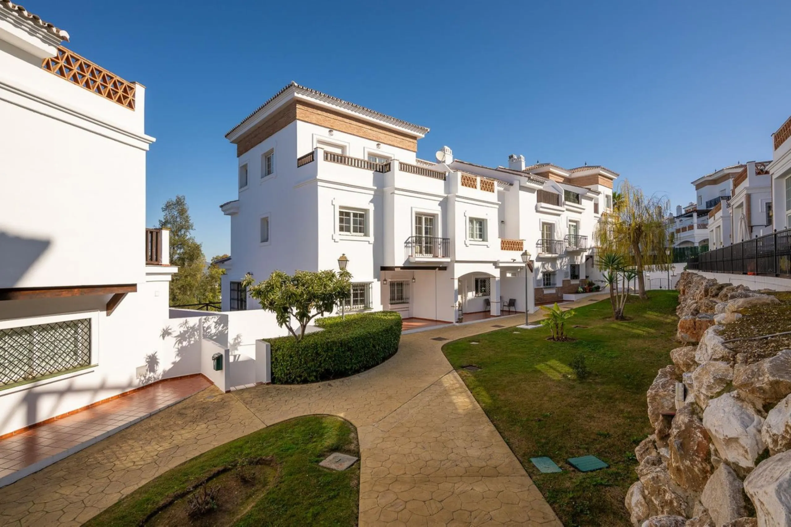 Townhouse for sale in Lauro Golf one of the most prestigious golf courses in Malaga. The property is distributed over three floors. On the ground floor there is a fully equipped kitchen, a toilet, a large living room with a fireplace that leads to a priva