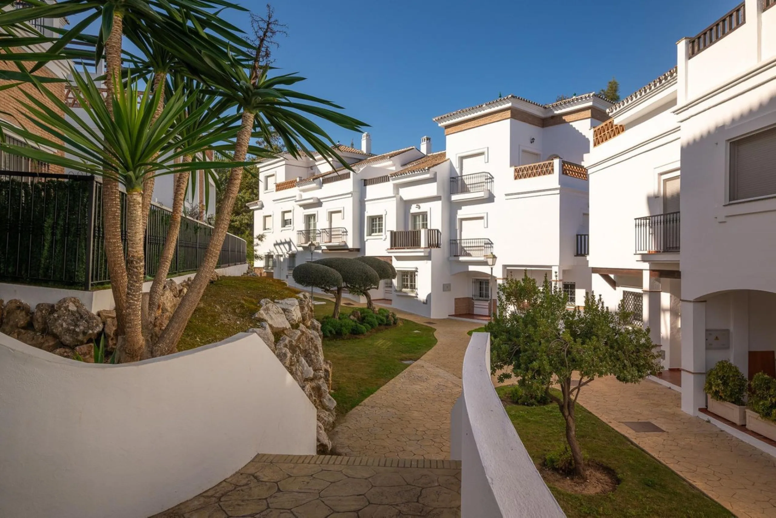 Townhouse for sale in Lauro Golf one of the most prestigious golf courses in Malaga. The property is distributed over three floors. On the ground floor there is a fully equipped kitchen, a toilet, a large living room with a fireplace that leads to a priva