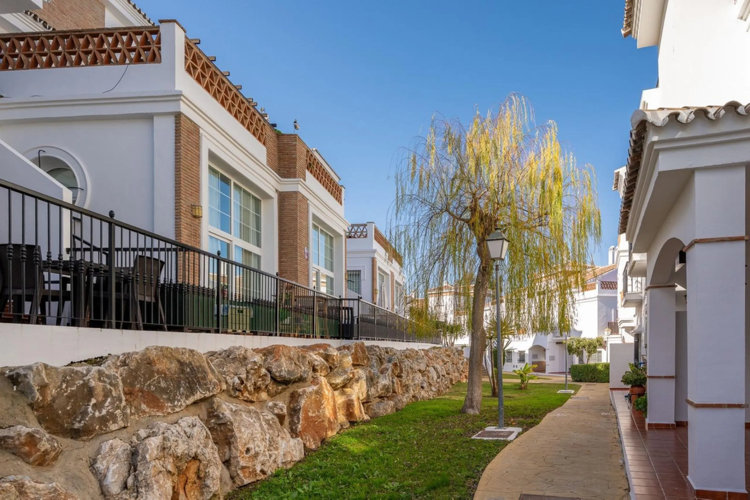 Townhouse for sale in Lauro Golf one of the most prestigious golf courses in Malaga. The property is distributed over three floors. On the ground floor there is a fully equipped kitchen, a toilet, a large living room with a fireplace that leads to a priva