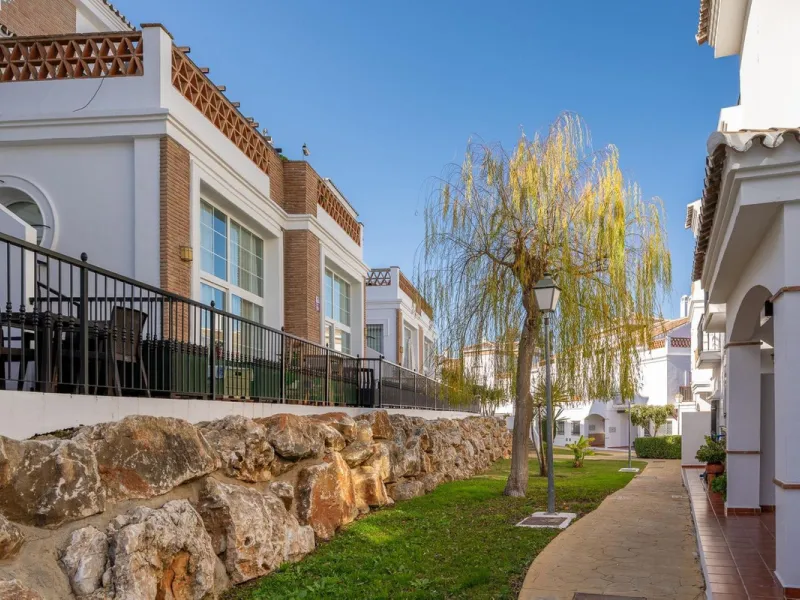 Townhouse for sale in Lauro Golf one of the most prestigious golf courses in Malaga. The property is distributed over three floors. On the ground floor there is a fully equipped kitchen, a toilet, a large living room with a fireplace that leads to a priva