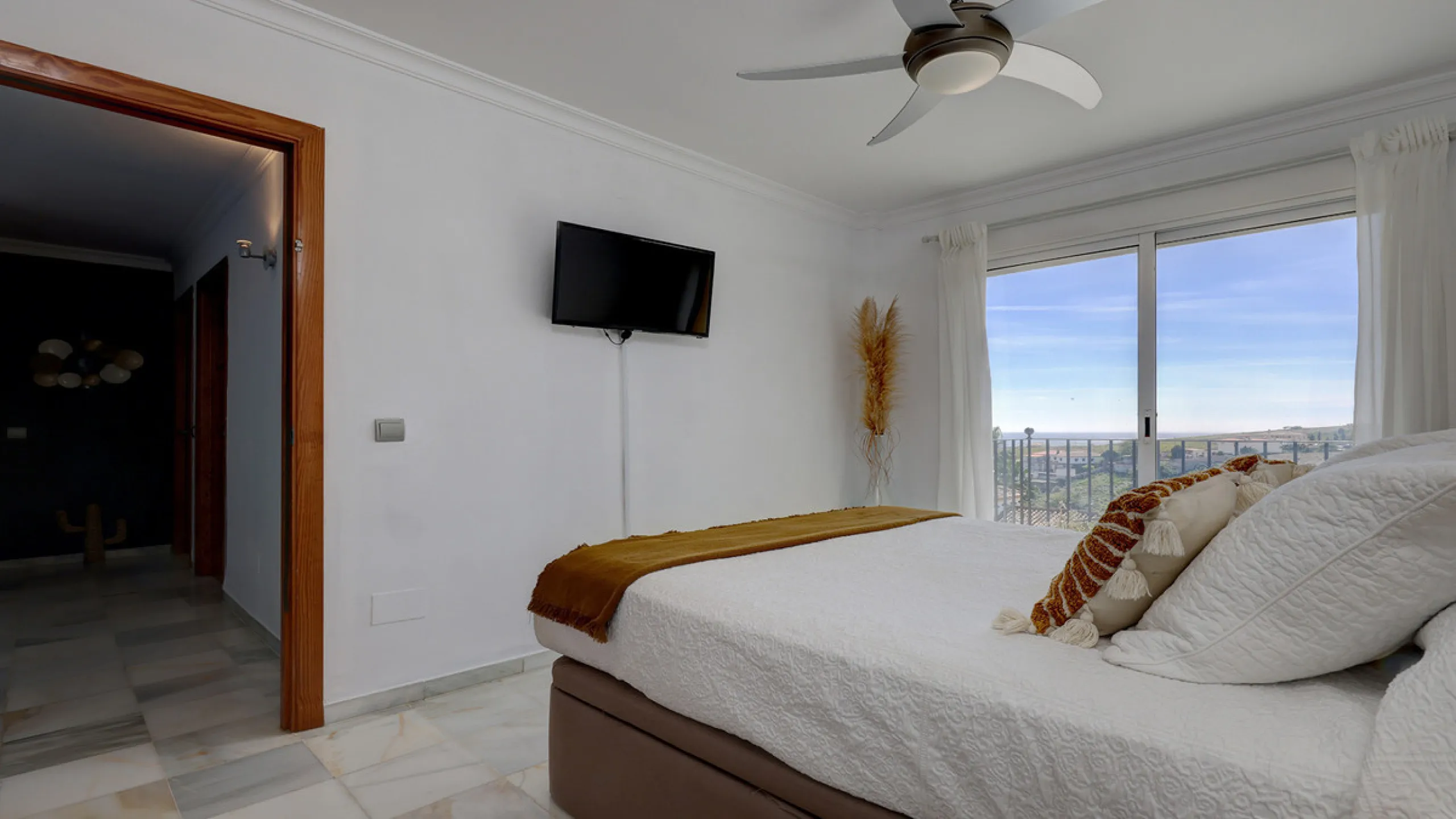 A fabulous Andalucian-style townhouse in Manilva Village with stunning panoramic views over the vineyards, across to the mountains and sea. A stunning setting. Located in a small urbanisation of only 23 houses with a communal pool and gardens.